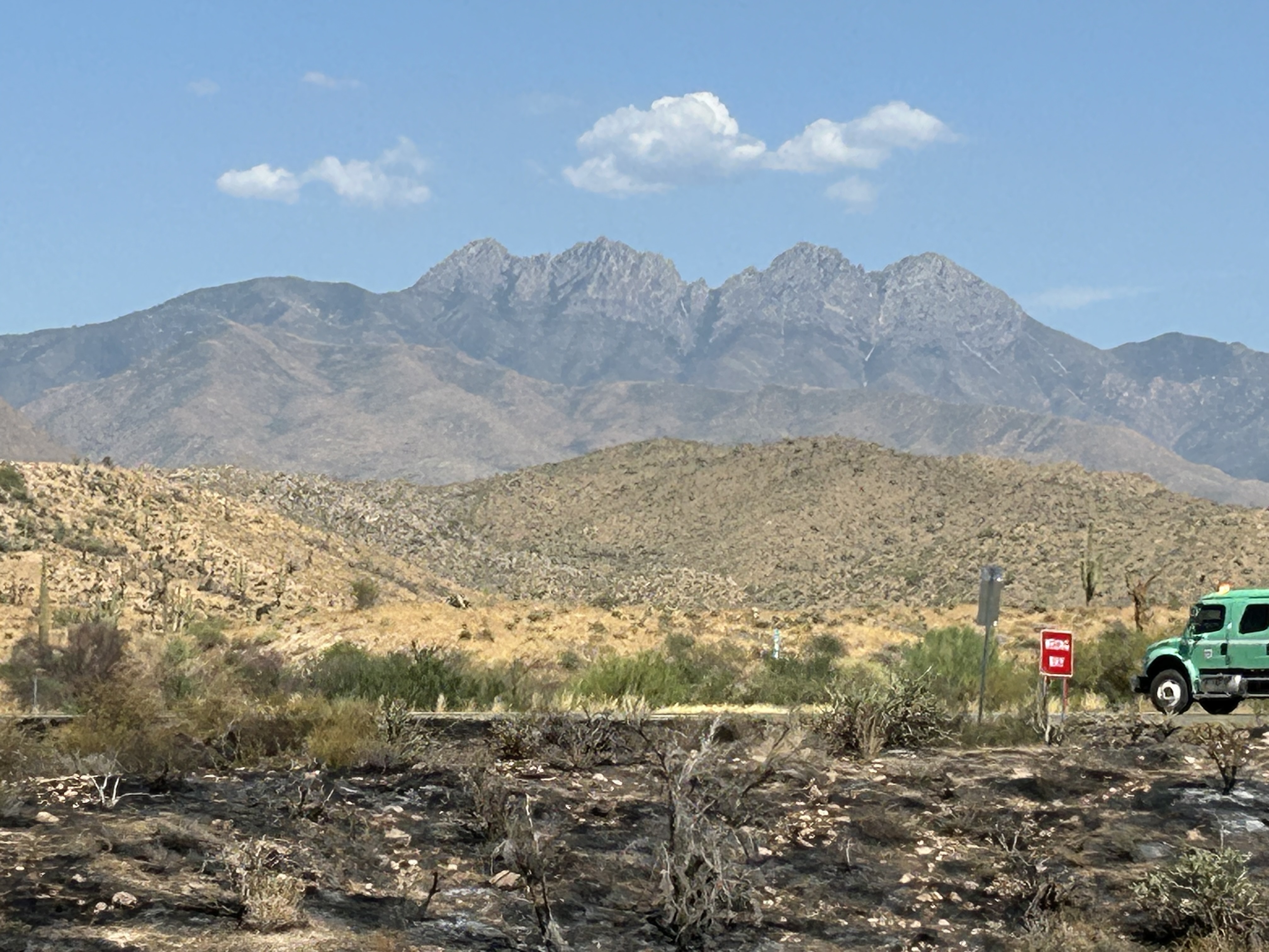 

						7-30-2024 Engine with smoke from Sand Stone Fire and Four Peaks in background
			