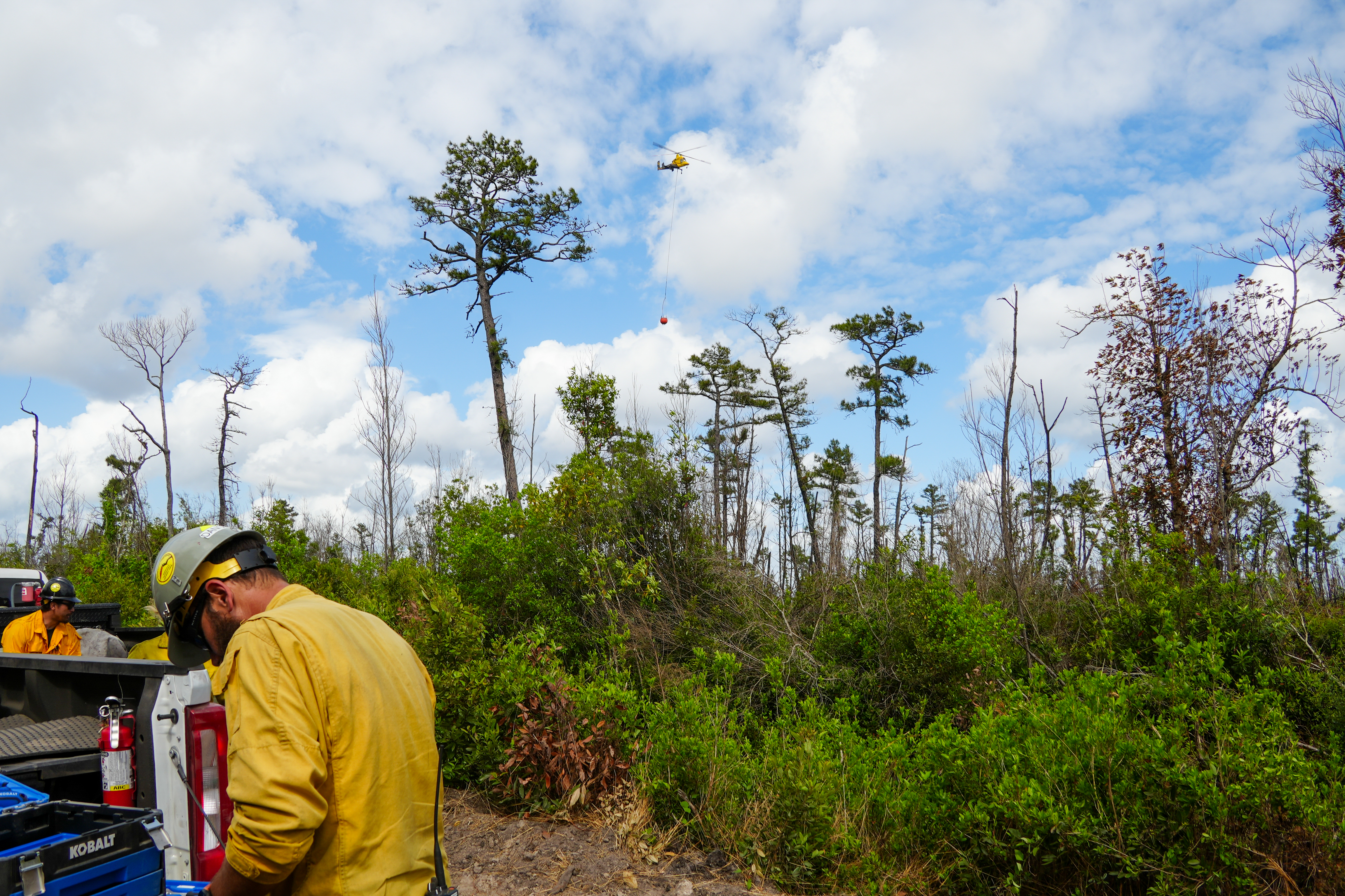 







						Firefighter with helicopter in background
			


