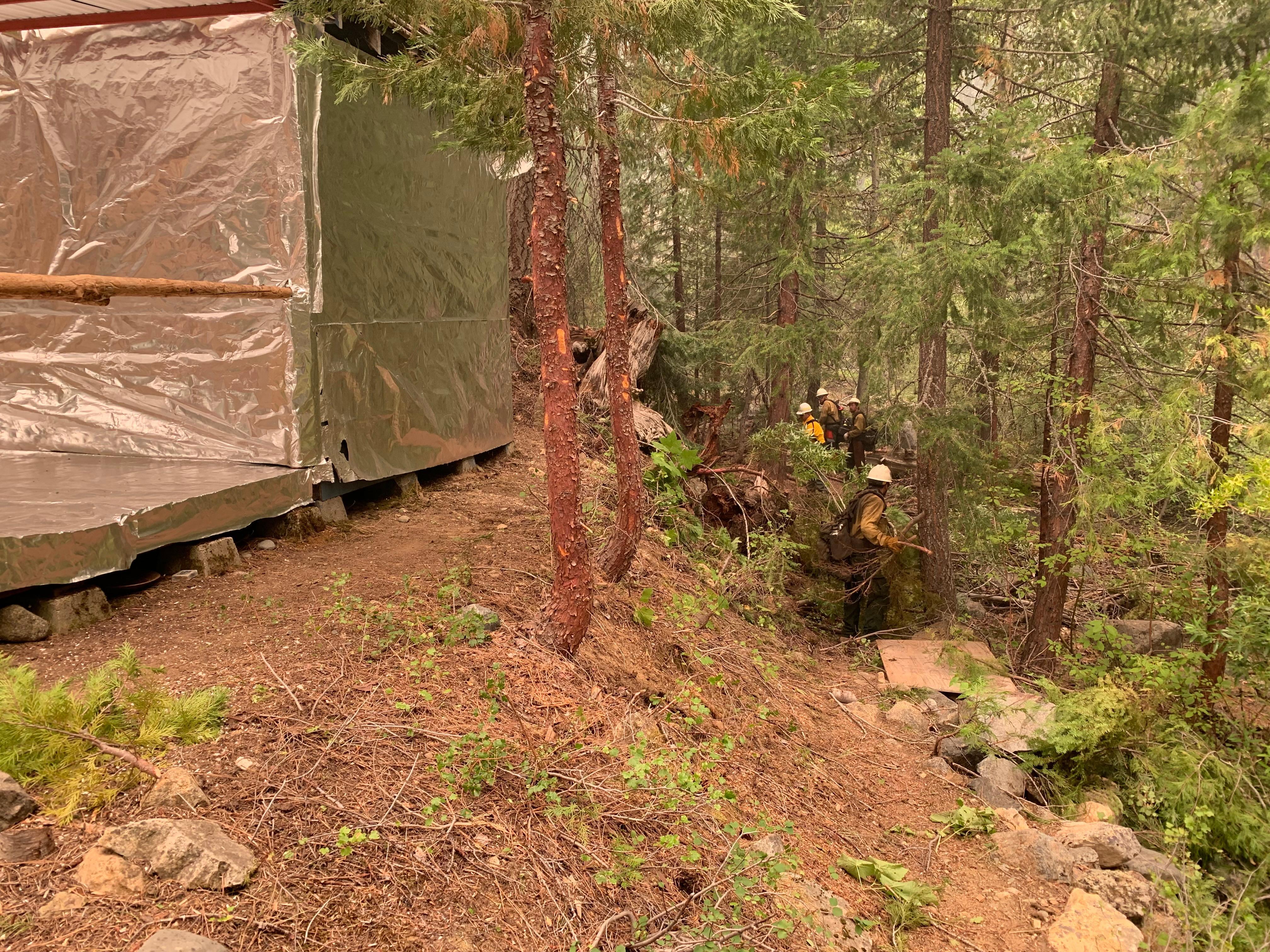 Crews with Firestorm Wildland Fire Suppression perform structure defense operations in the Coffee Creek Road Community.
