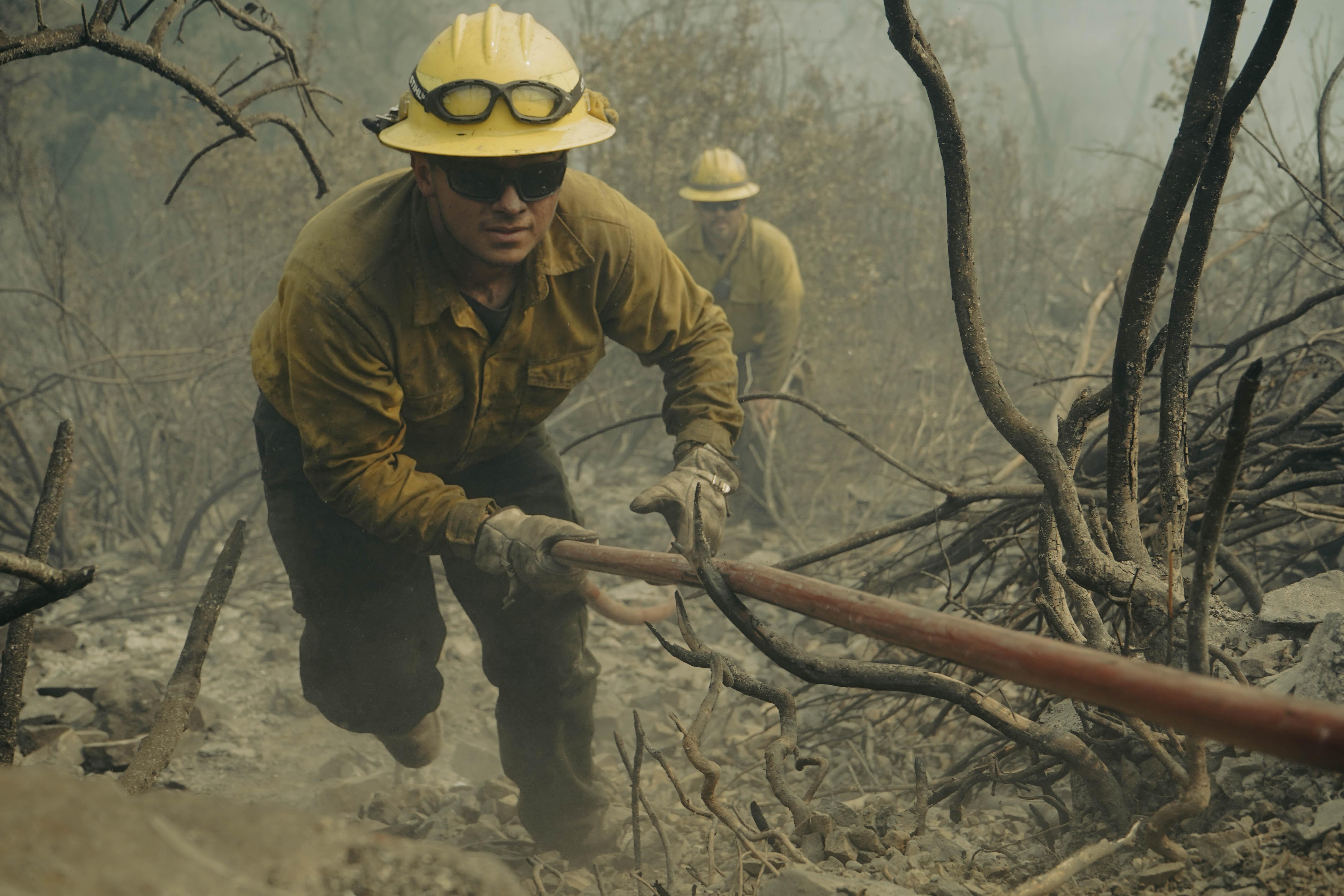 Firefighter Jessie Williams of Division Alpha/Hotel makes his way up on a hardline. Crews with the Montrose, Colo. Based Montrose Hell Fighters work putting out spot fires on the Cronan Fire, part of the River Complex, Aug. 22, 2021.