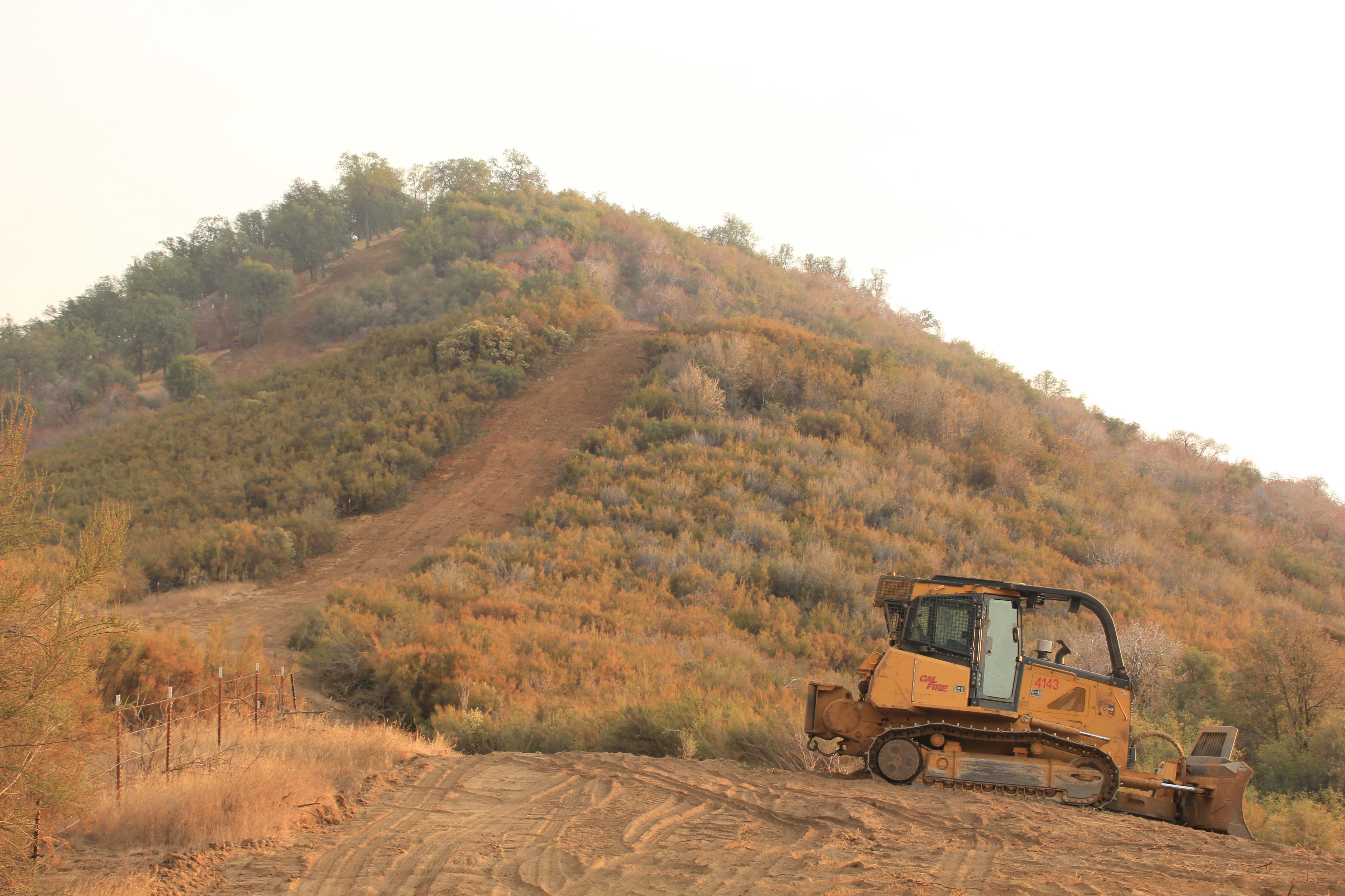 A pushed out bulldozed area with 4 dozers parked