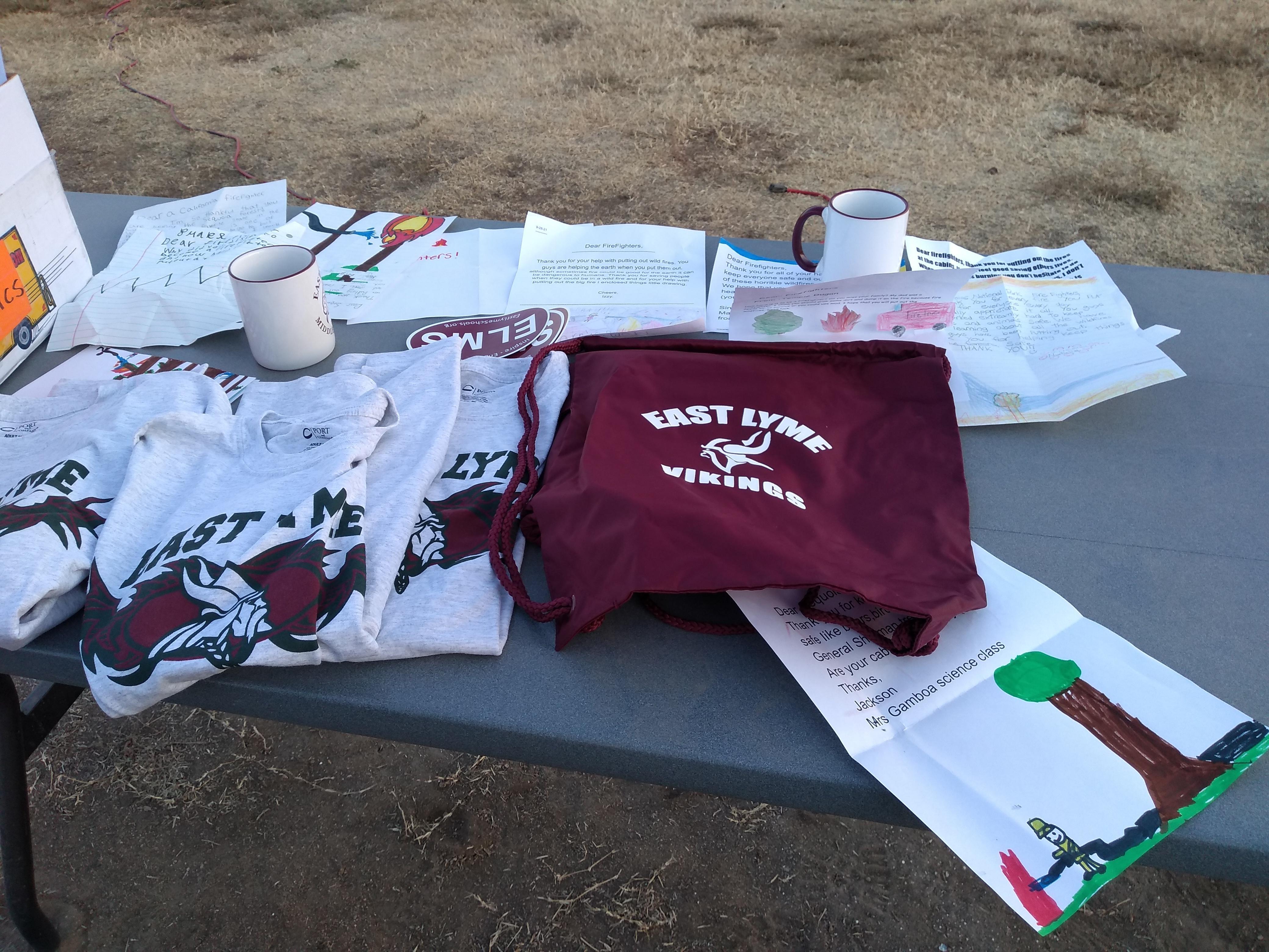 A table with colorful letters from students plus T-shirts, mugs, stickers and bags with the East Lyme Middle School Vikings logo.