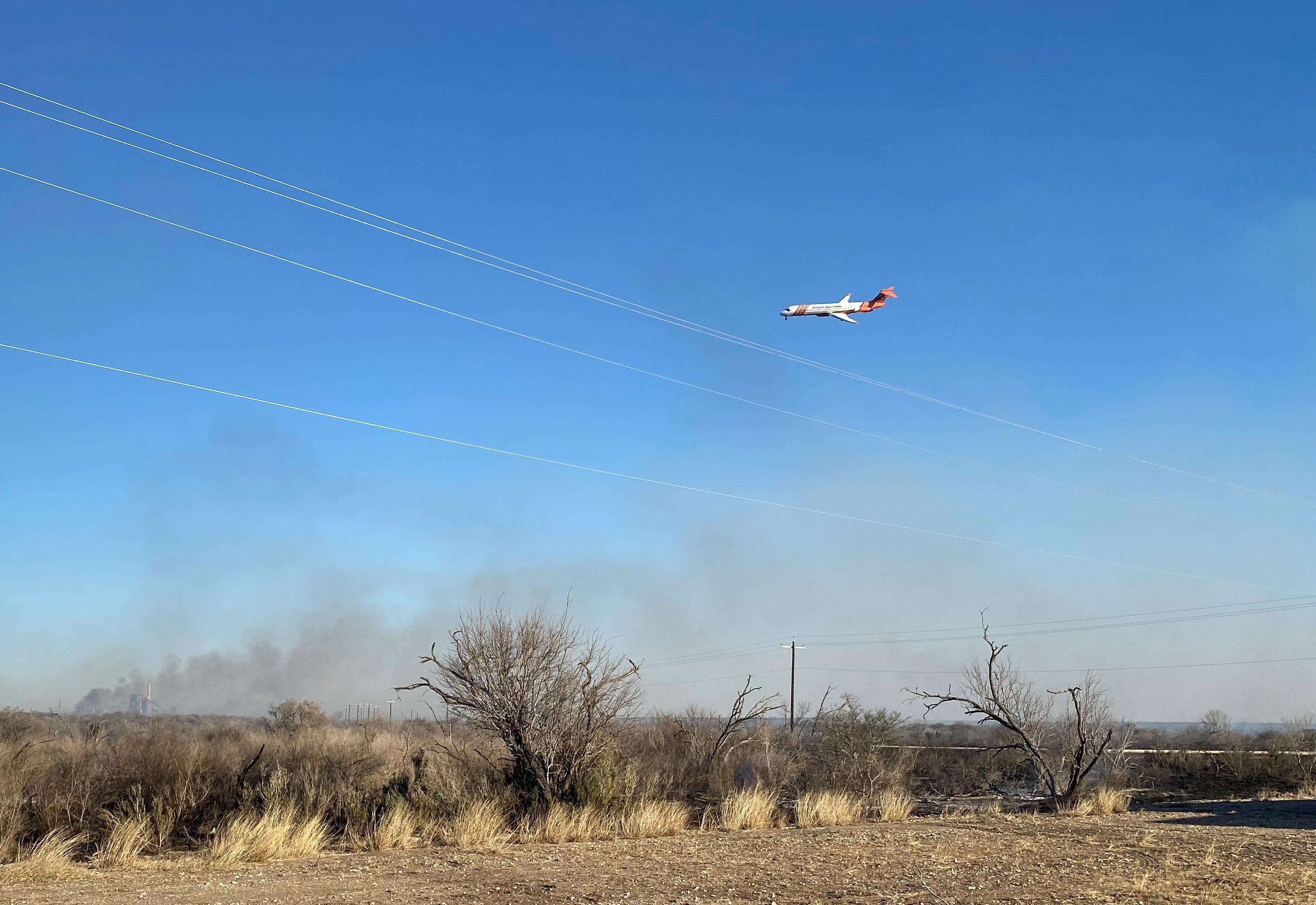 A jet equipped with tanks of retardant, referred to as a Large Air Tanker (LAT) circles over the Christine Fire looking for where to drop.