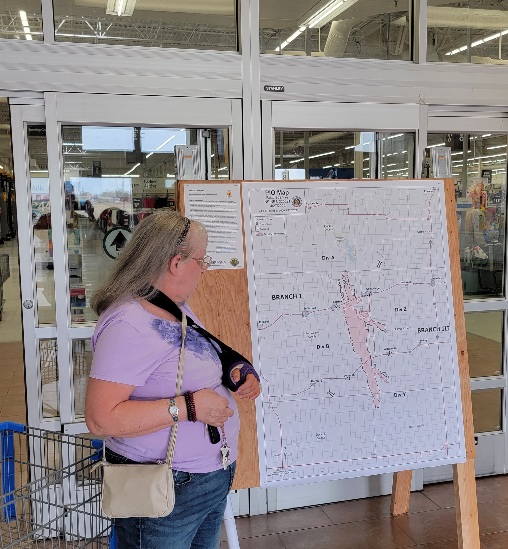 A woman is reviewing the information and map on a board at Walmart.