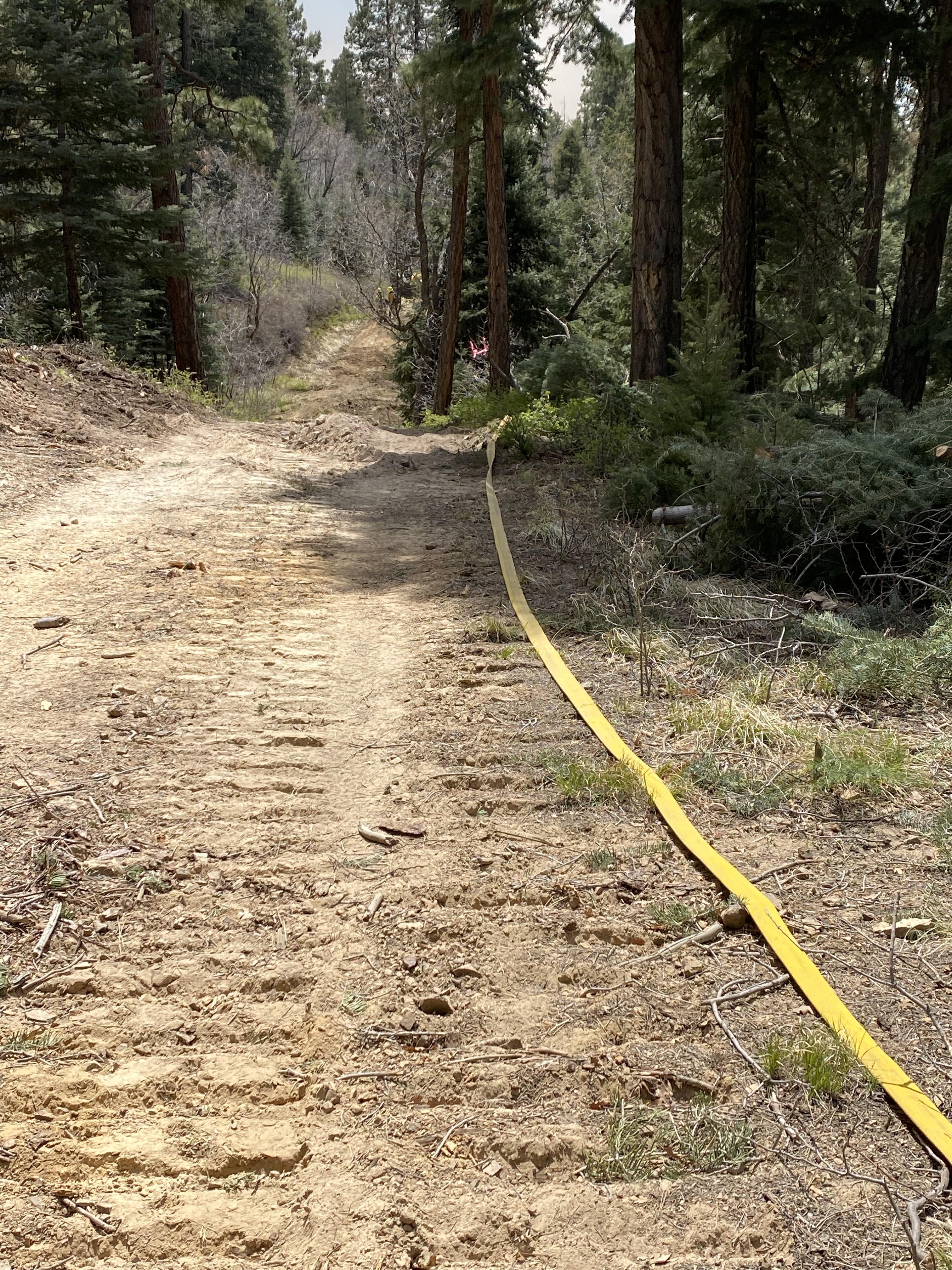Crews install fire hose along fireline