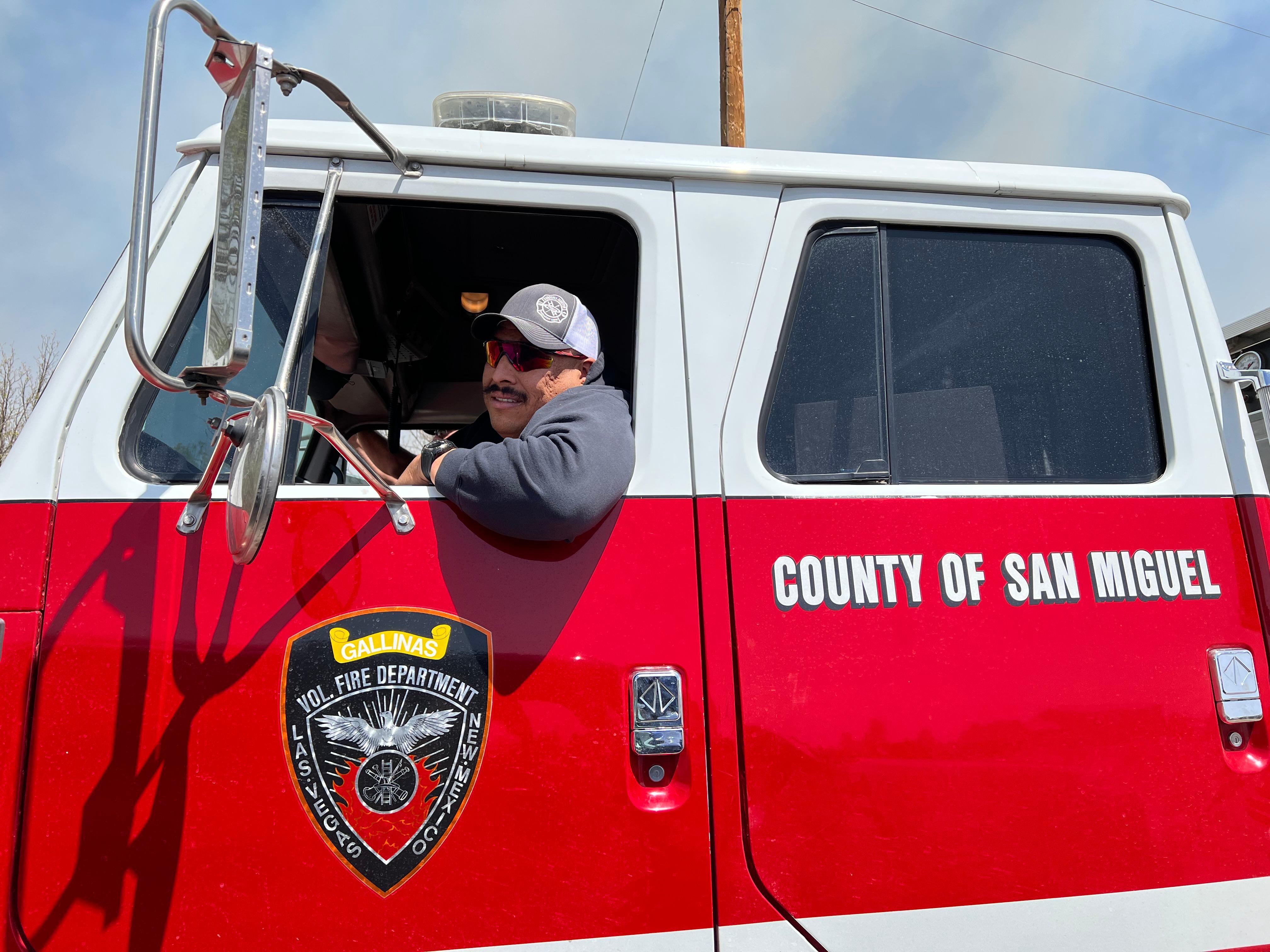 A firefighter with the San Miguel County Volunteer Fire Department pauses while on patrol in Las Vegas, New Mexico.