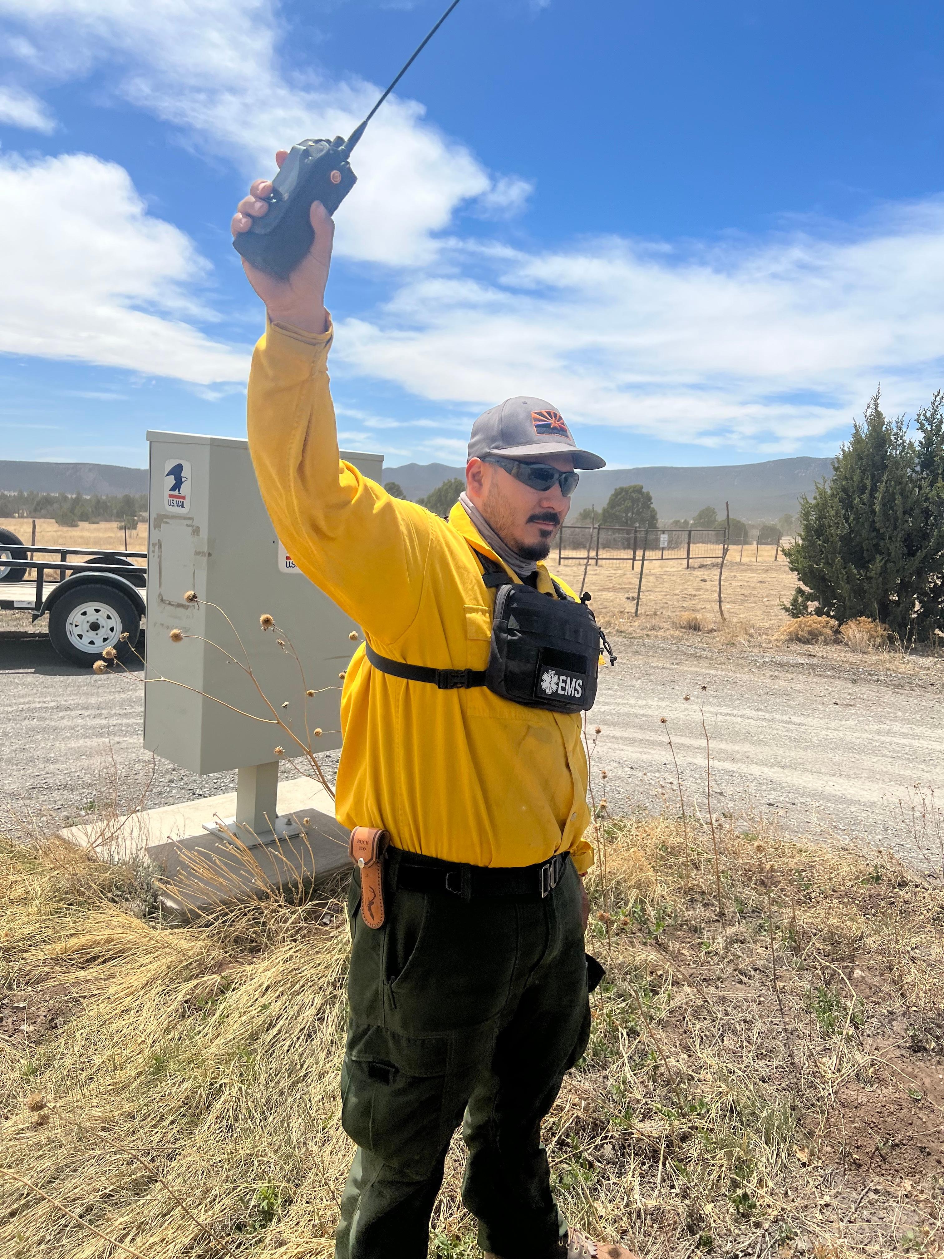 Paramedic Joaquin Reyes of Phoenix holds his radio up to get better reception on May 9.