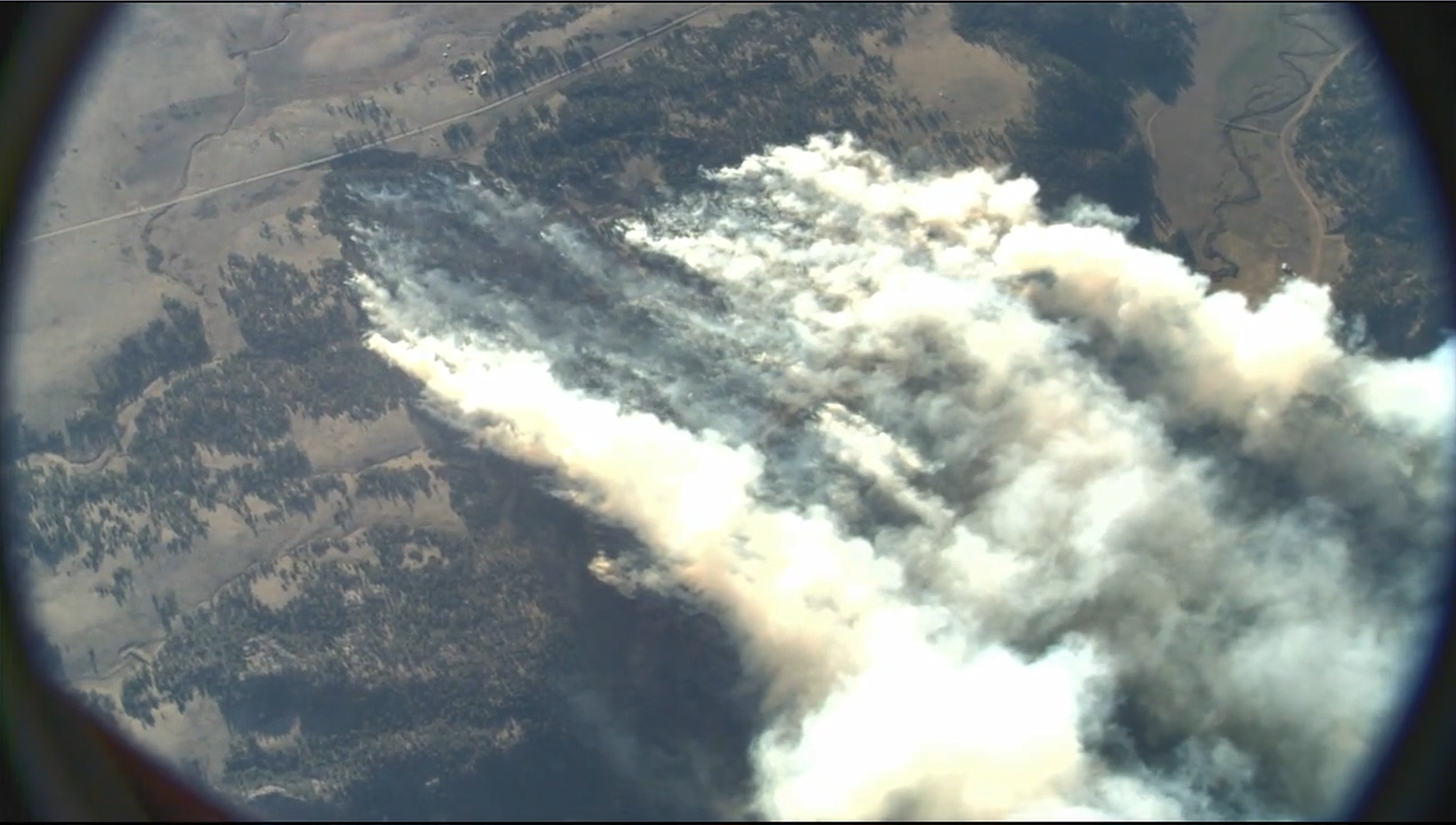 The aerial view shows a smoke column drifting from the High Park Fire