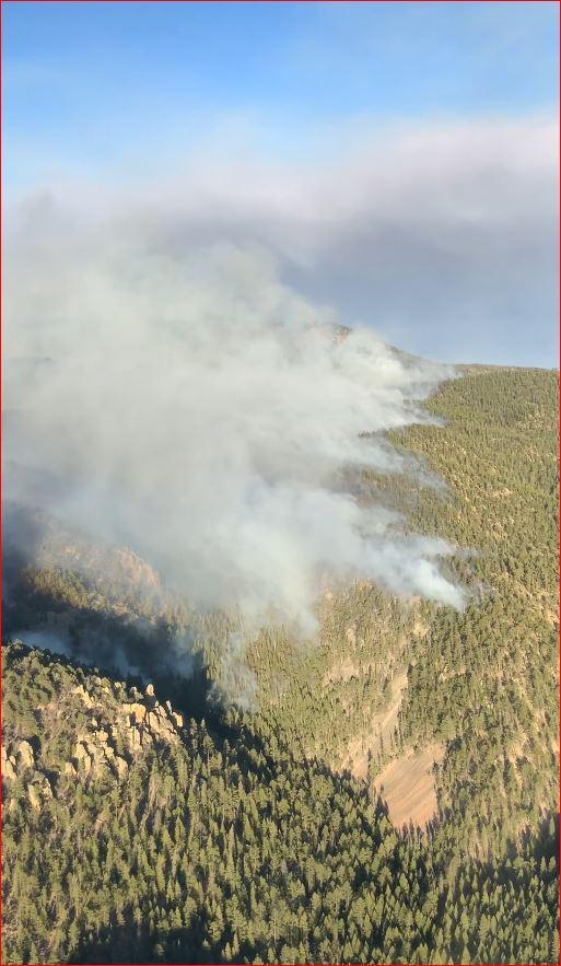 smoke rises from backing fire in steep terrain, 5/16