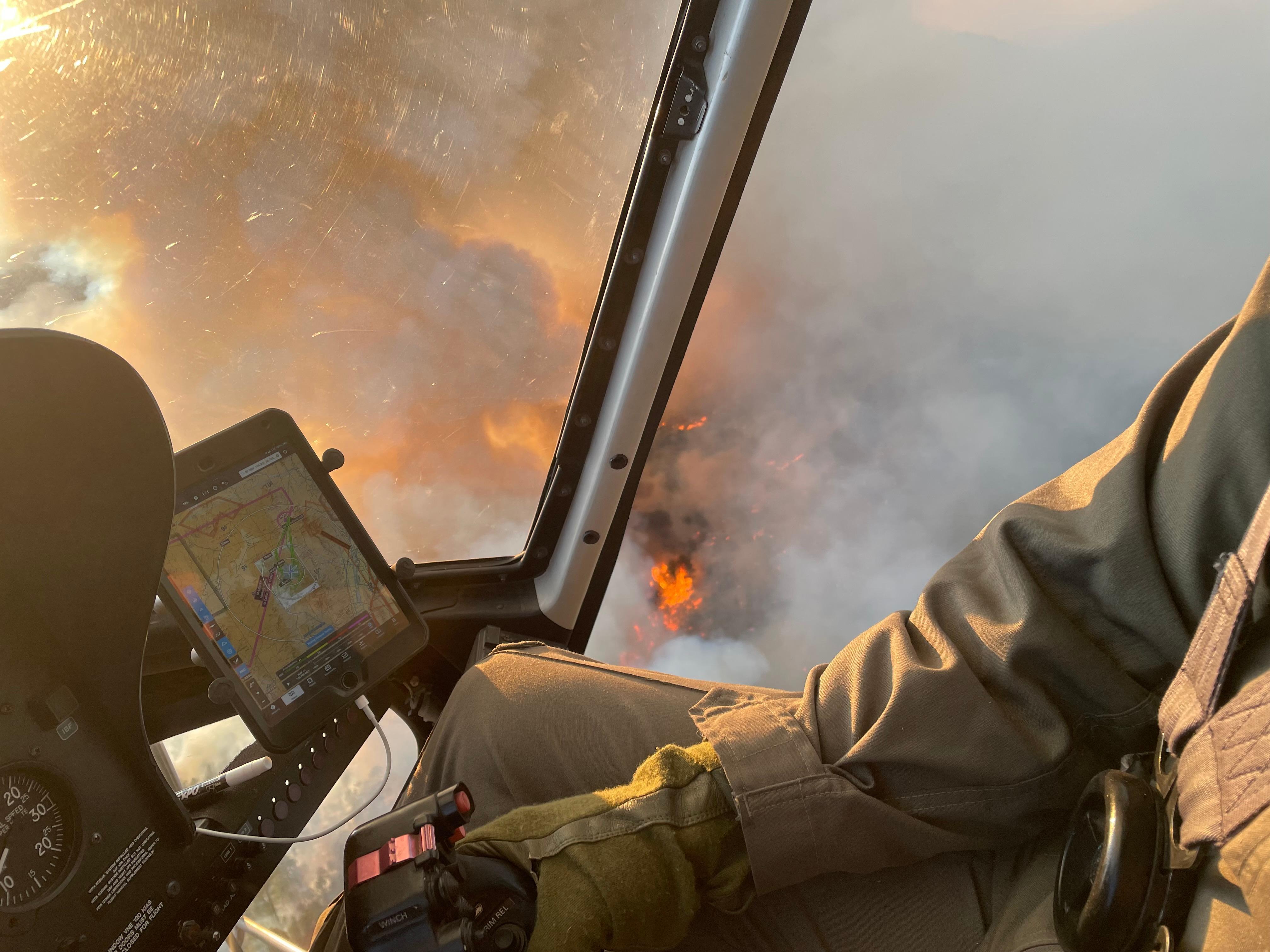 fire and smoke below as pilot view's from helicopter seat