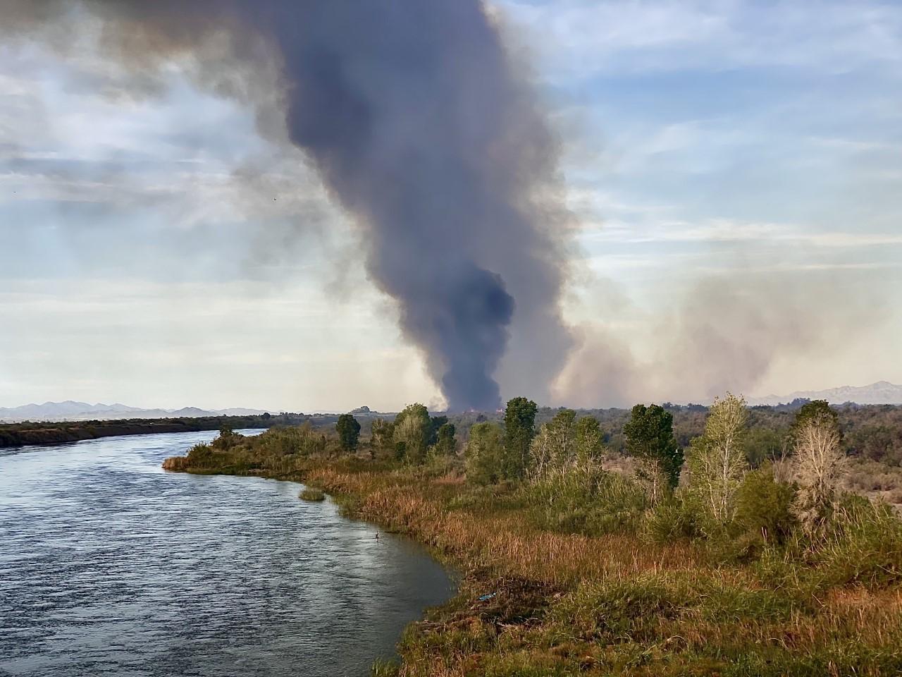 A small smoke column rises near the Colorado River near