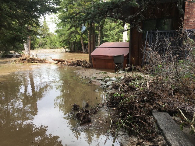 Muddy flood waters adjacent to a cabin