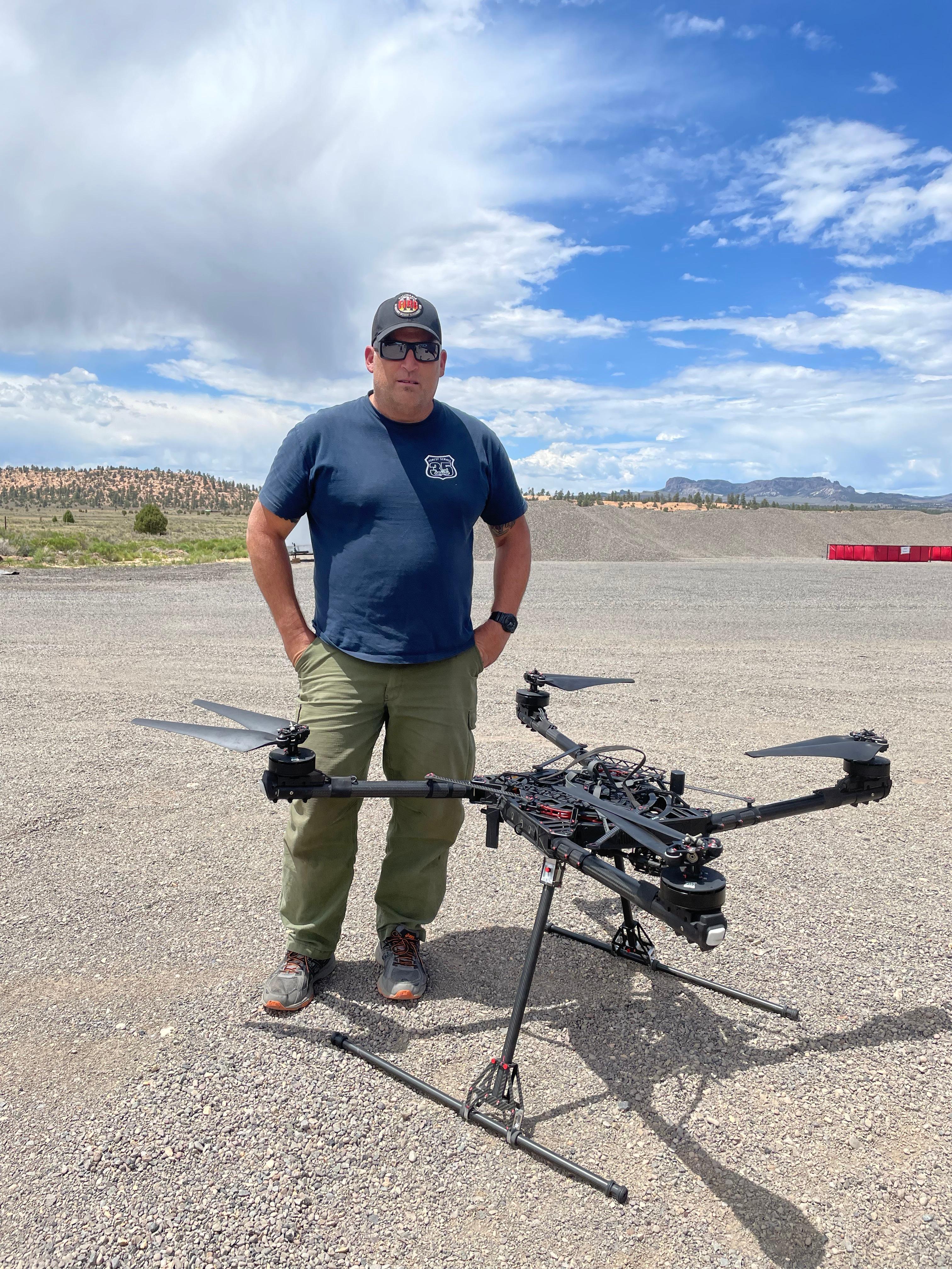 A man stands behind a fully assembled UAS.