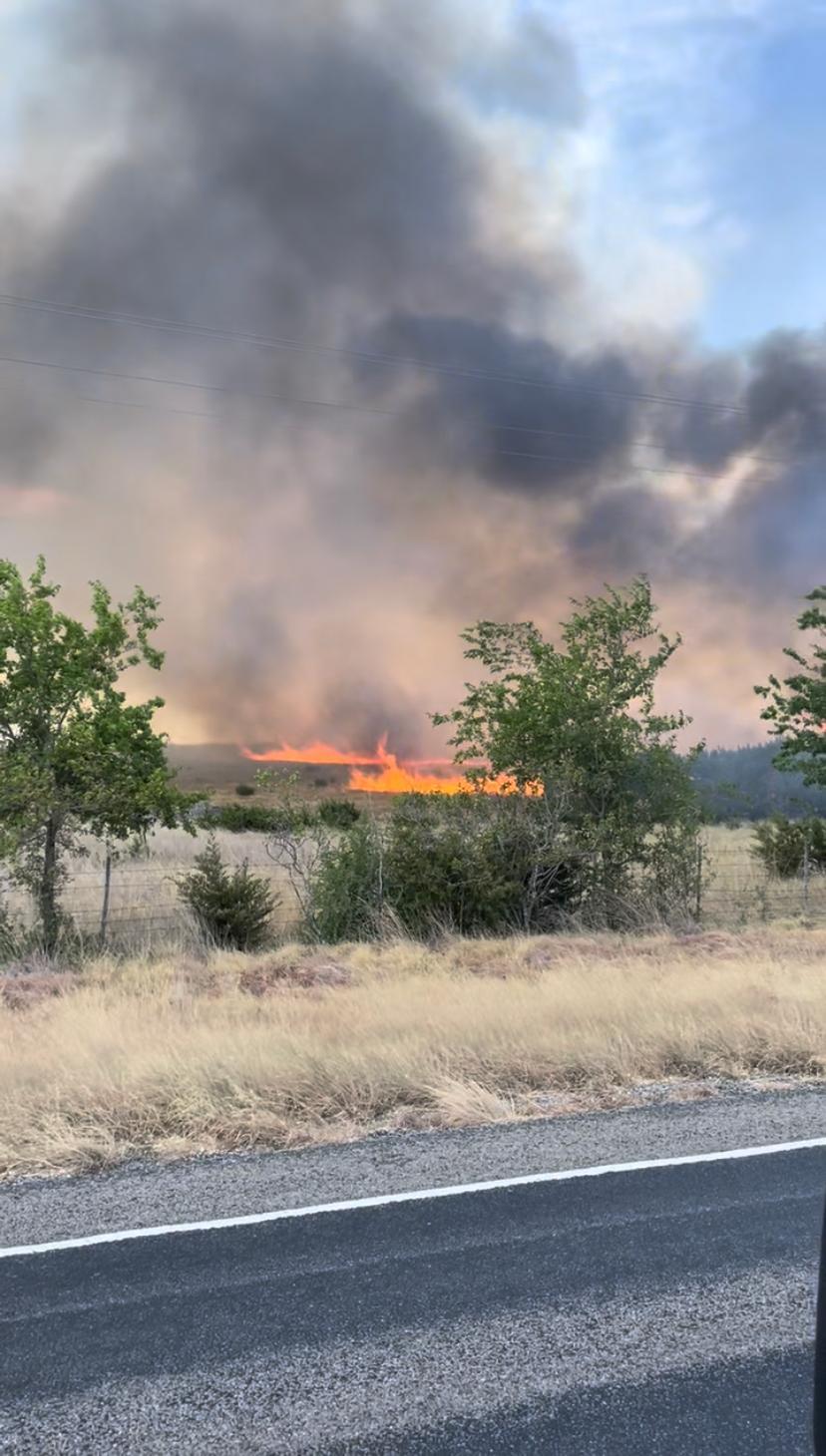 orange flames burning through a field putting off black smoke