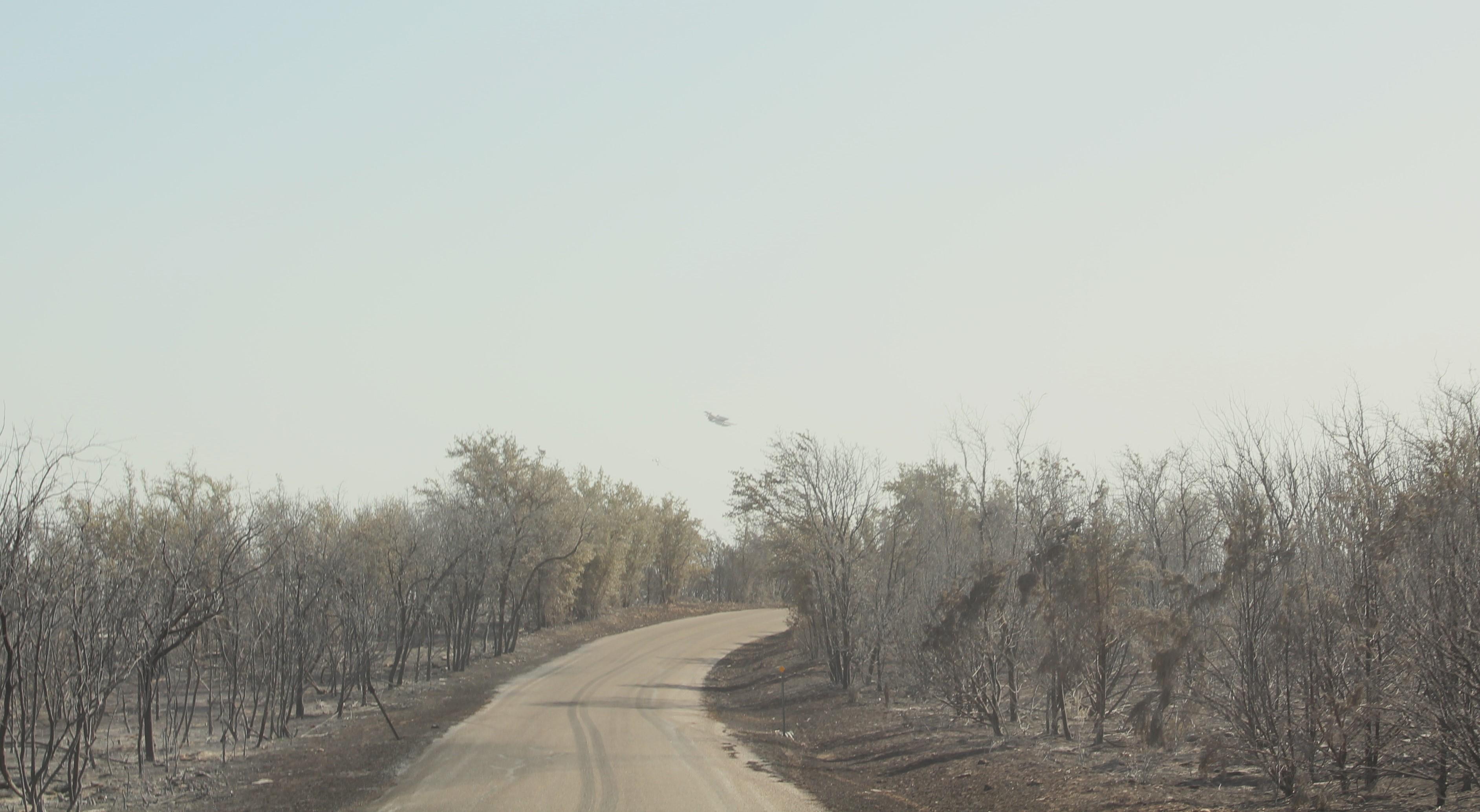 A plane flies over the Chalk Mountain Fire area, ready to drop retardant