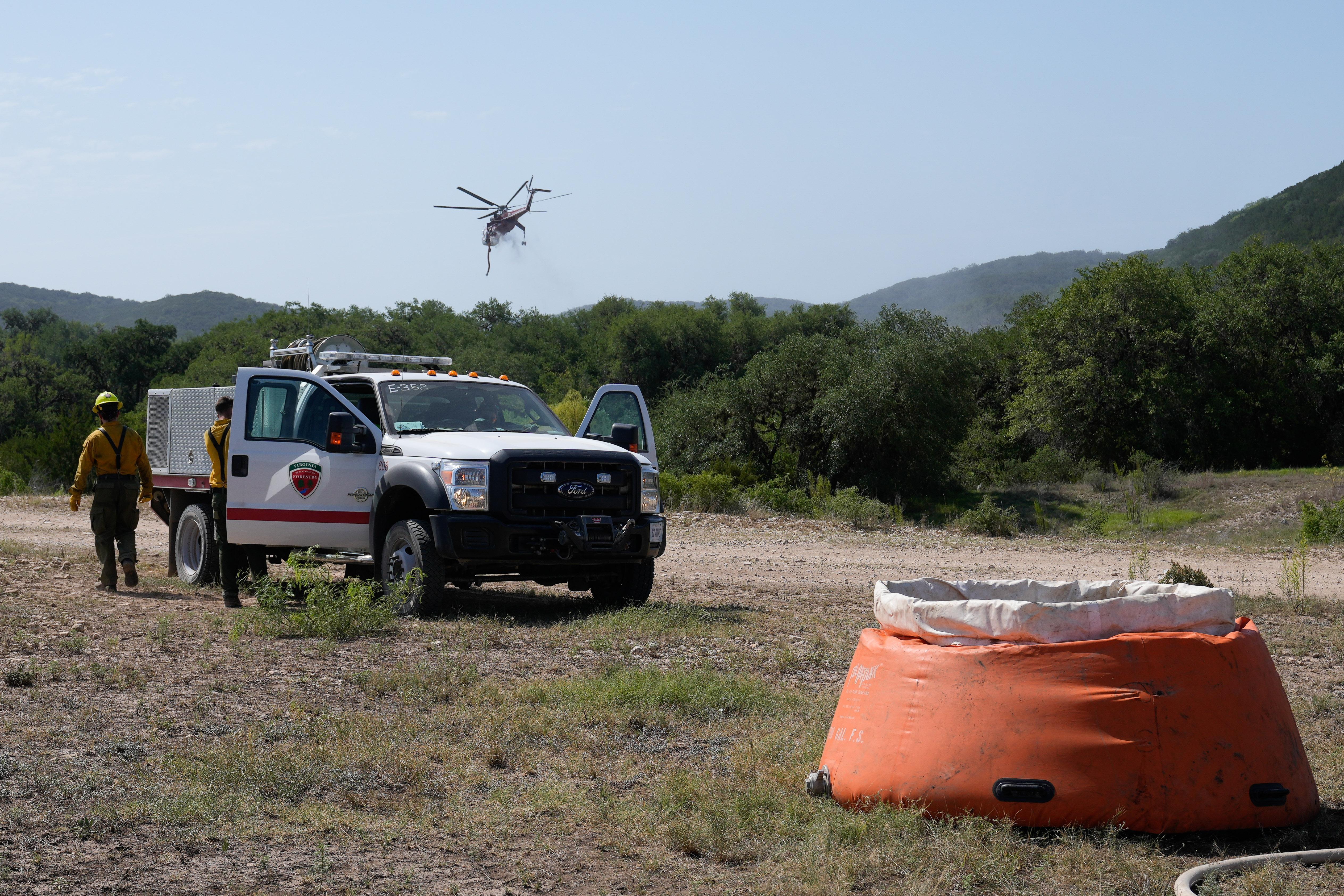 An engine is parked next to a pumpkin while a helicopter flies above