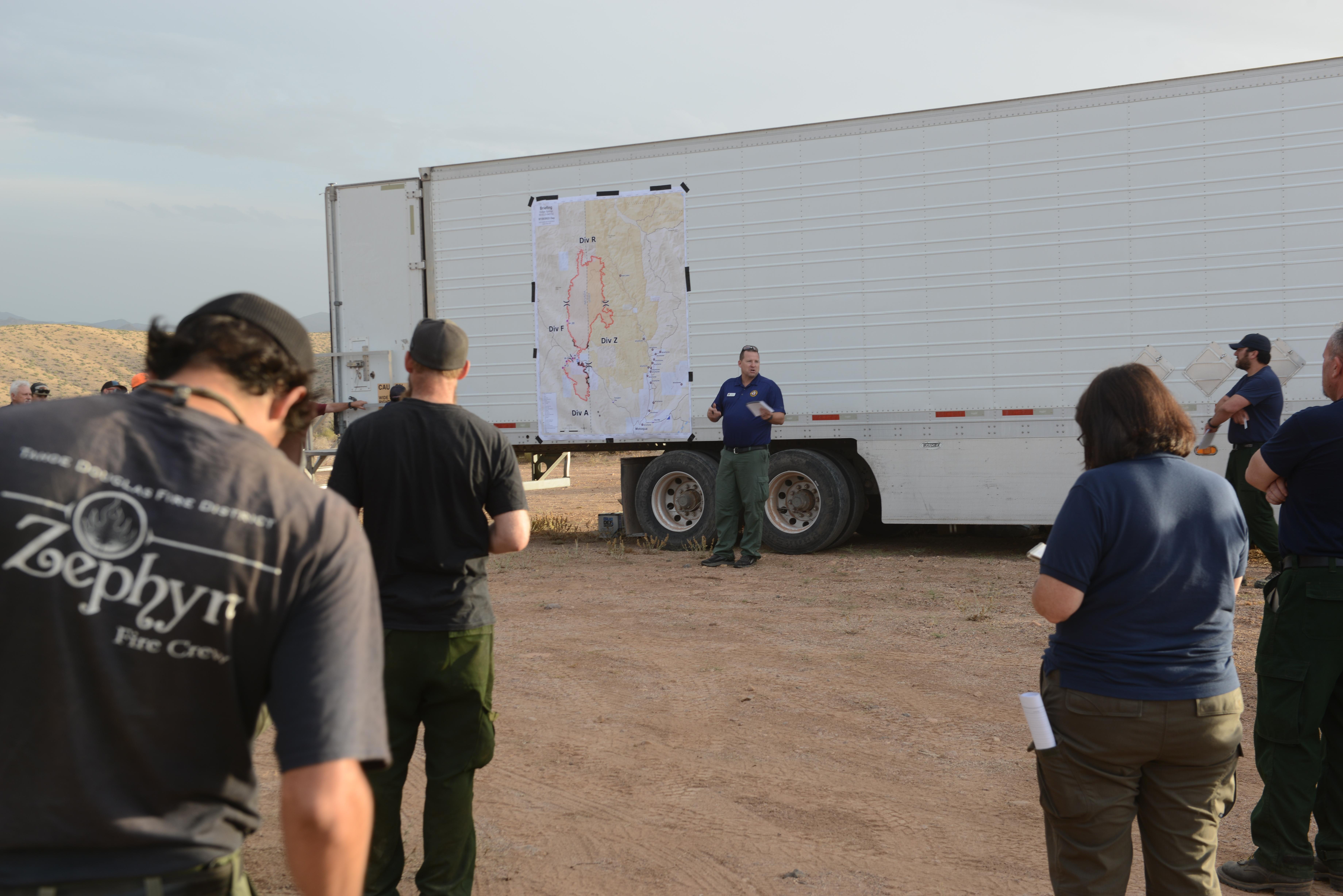 Wildland firefighters listen to the Dodge Creek Fire morning operations briefing July 25, 2022.