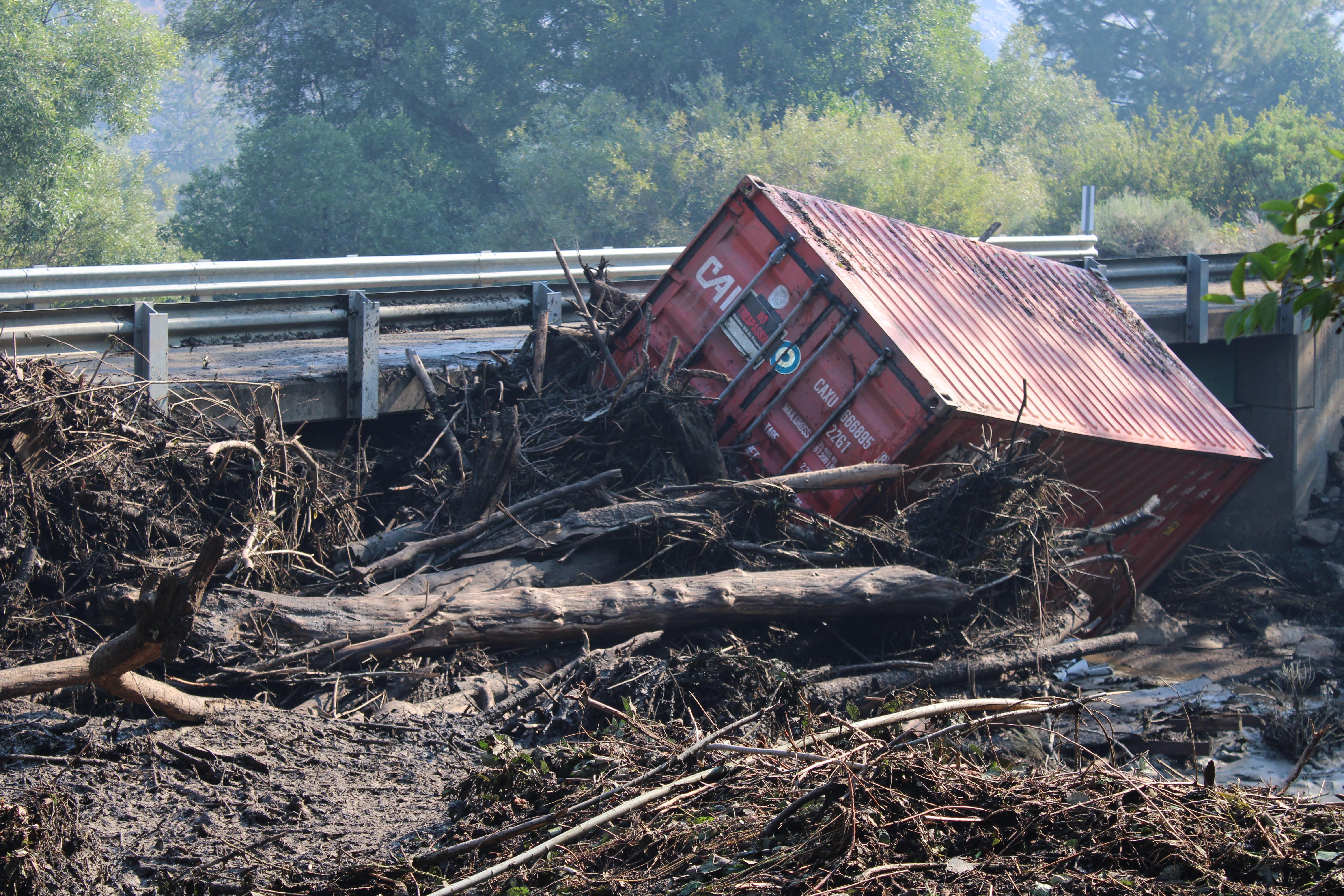 A conex box rests next to a bridge on Humbug Creek Road after heavy rains on the evening of August 2 caused localized flooding and debris flows