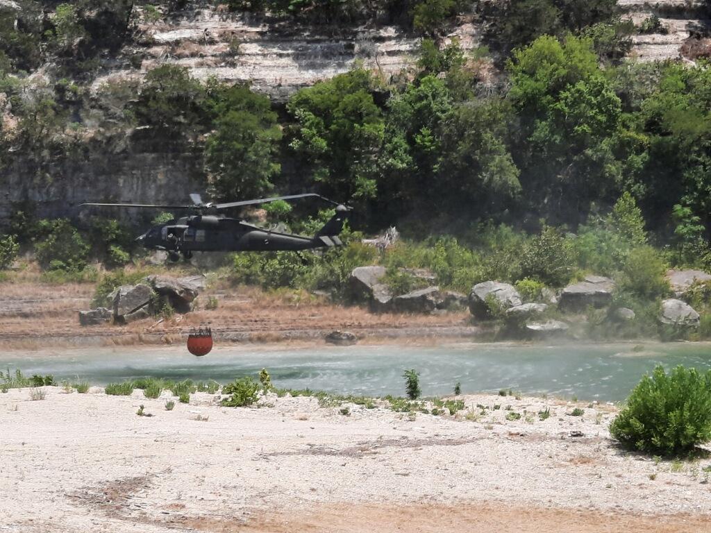 Helicopter drafts water from the Brazos Rover to respond to the Hermosa Fire in Hays County on August 4, 2022