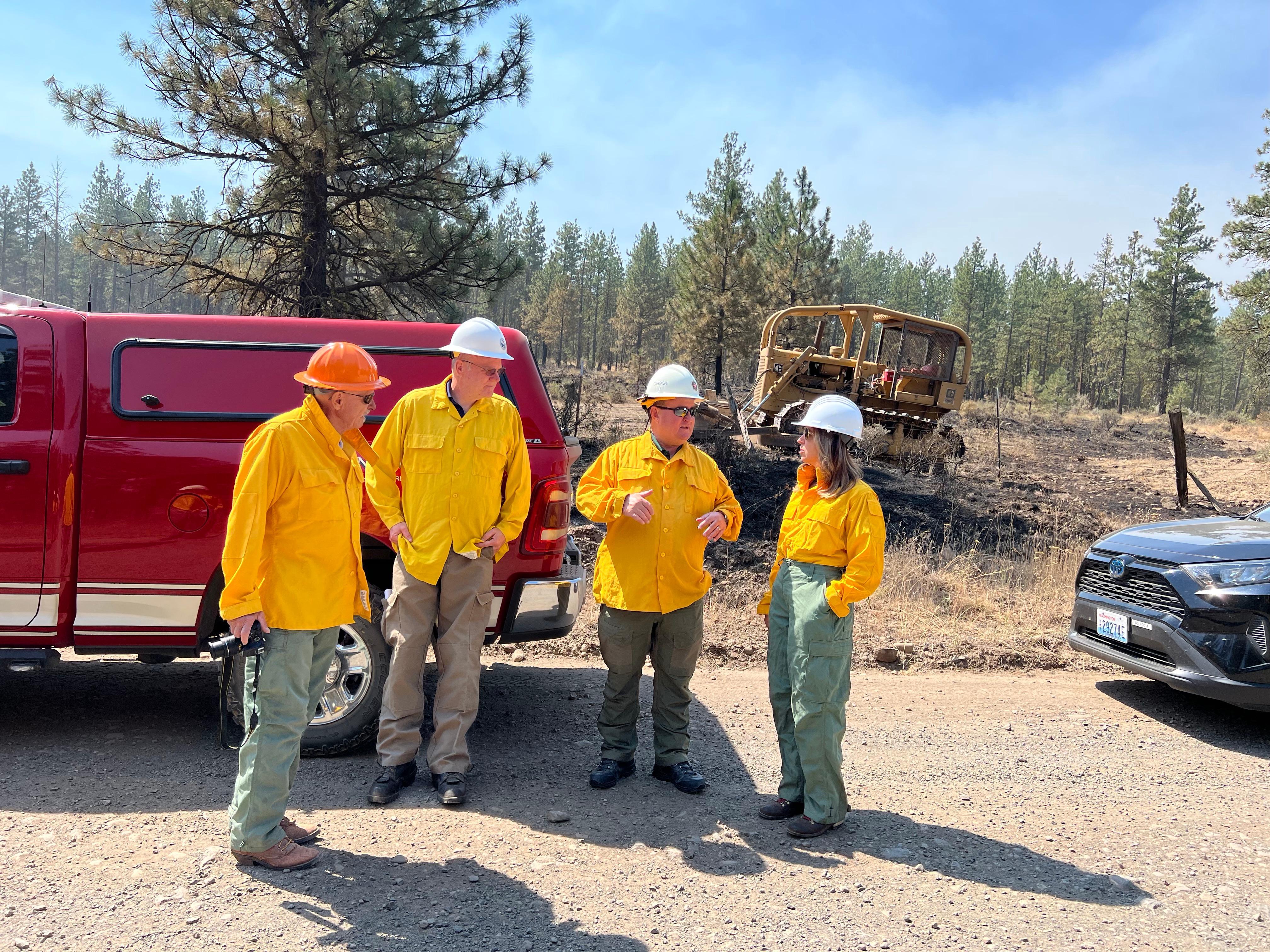 Deputy IC Schindelar escorts Hilary Franz and Tom Dent to the fireline where dozers had been working adjacent to a road. 8/6