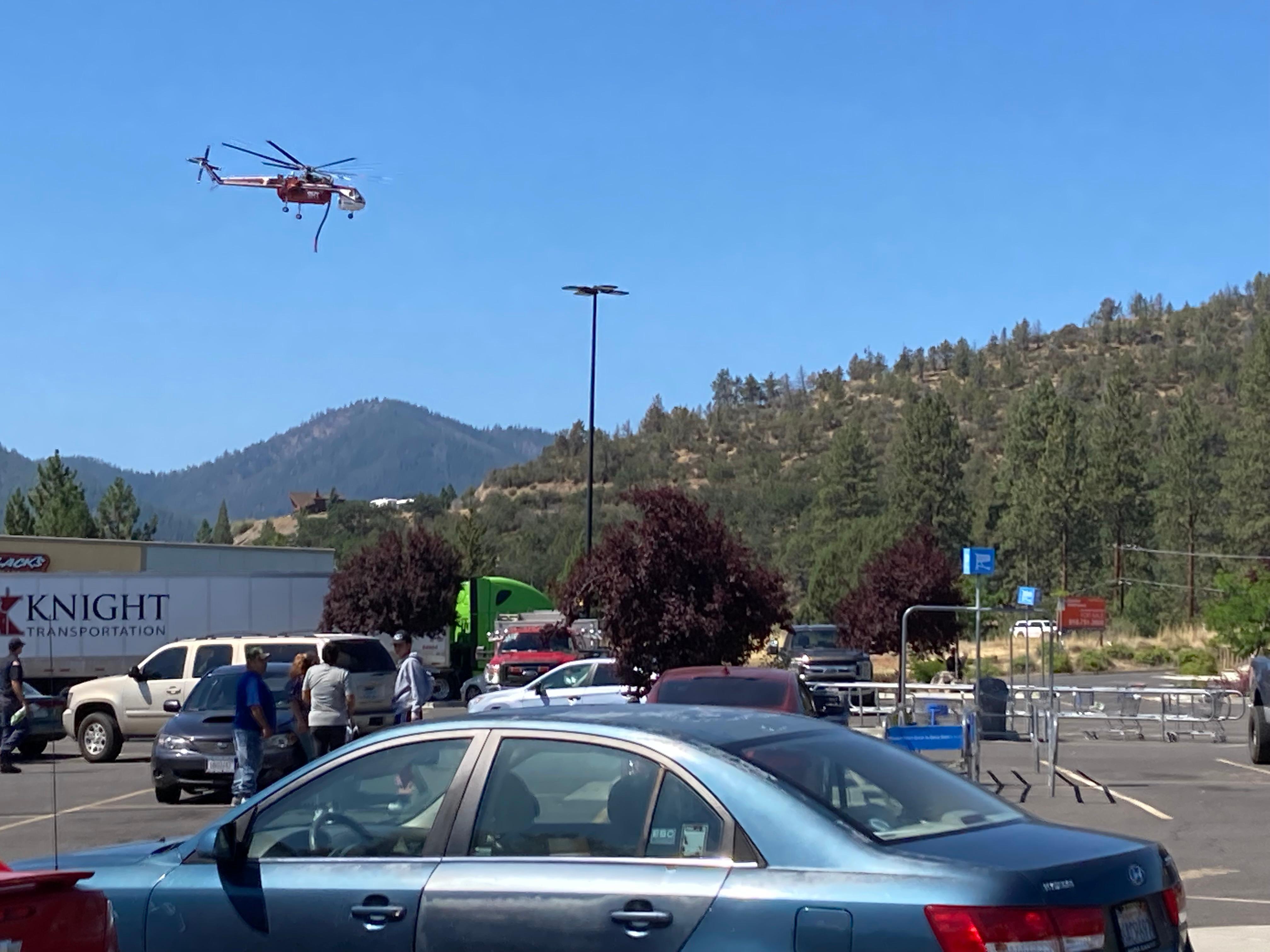 A helicopter flies low from the retardant plant near Walmart
