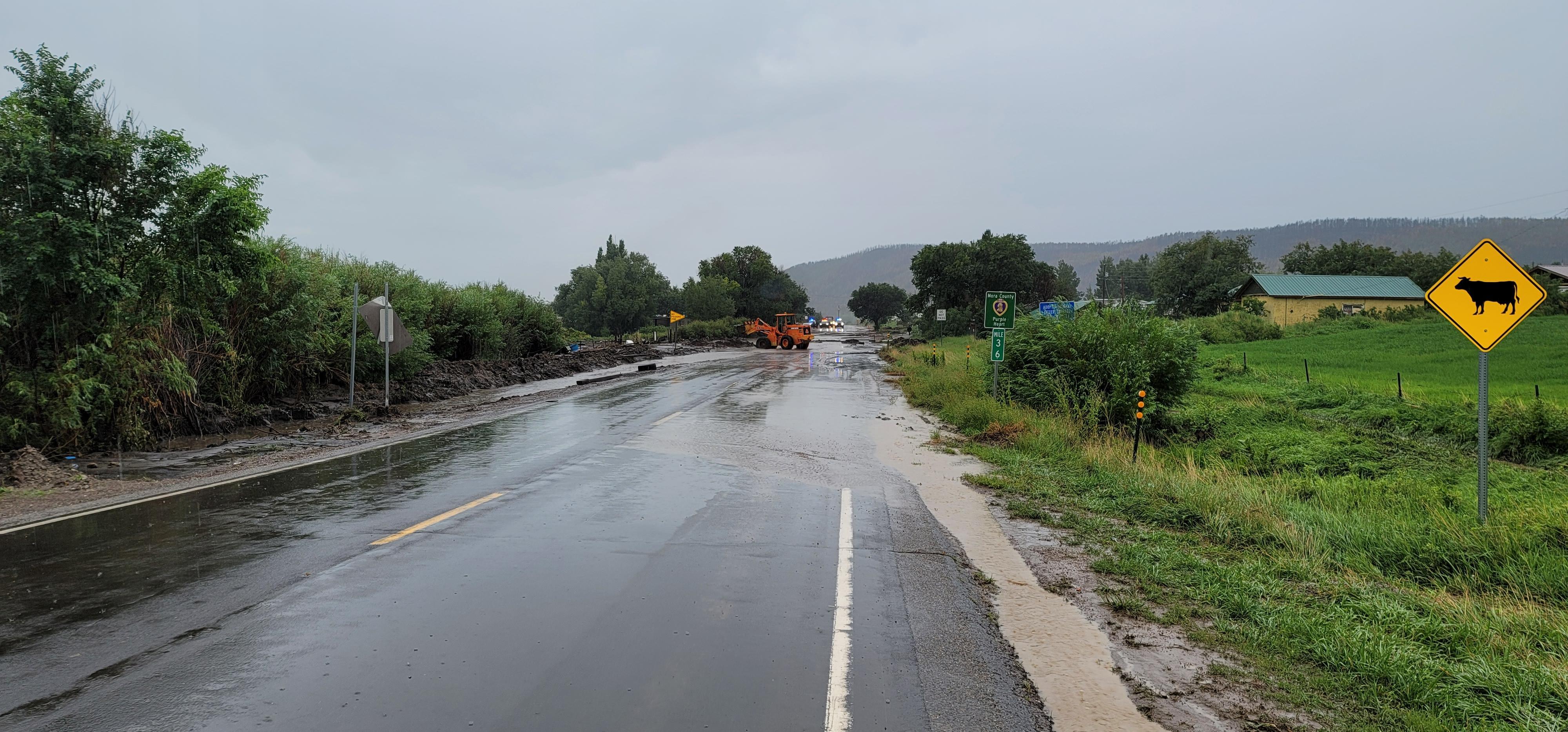 A front end loader removes flood debris from a road near  mile marker 36 in North Repair Group 08-08-22 