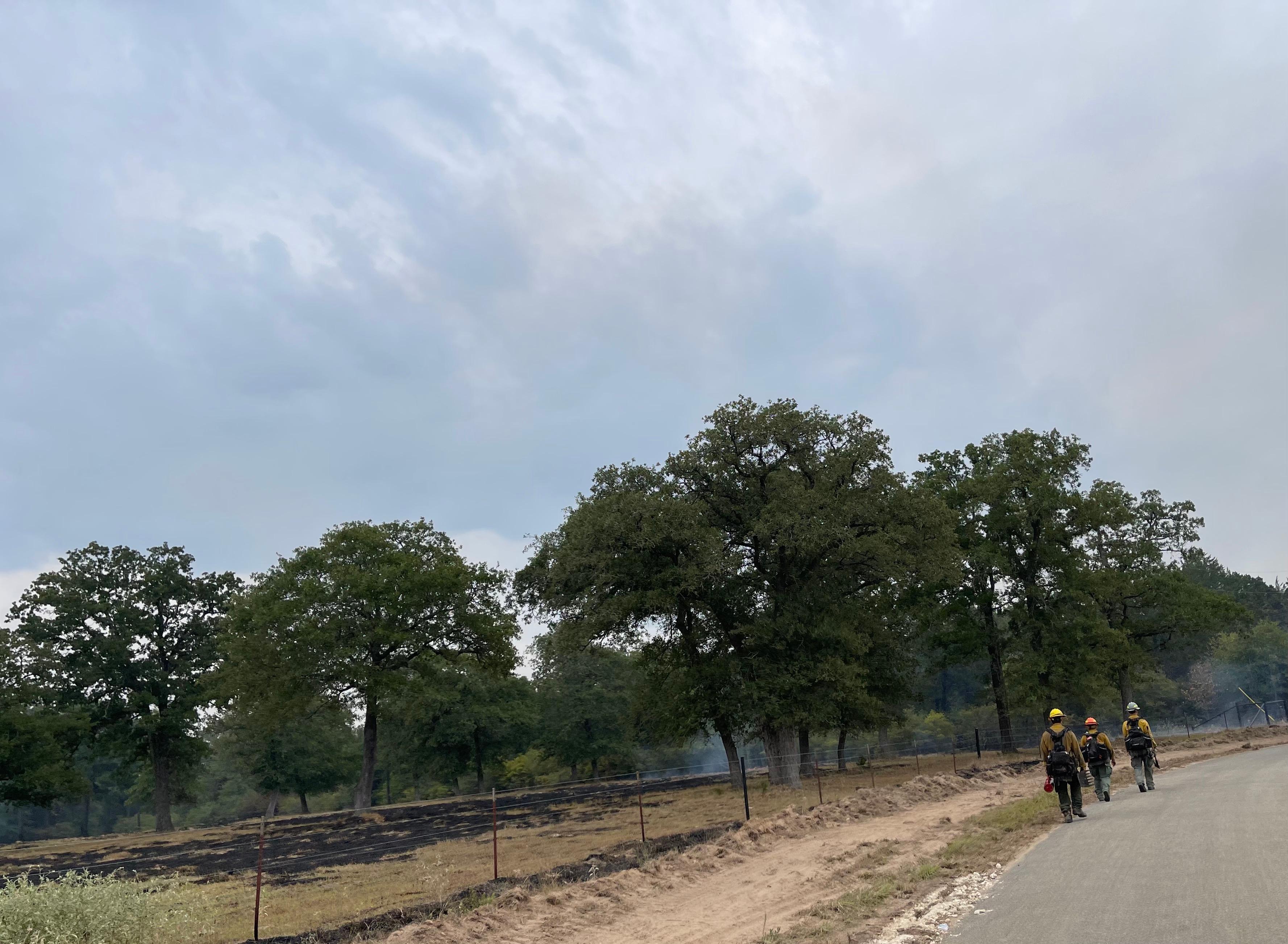 Fire Fighters patrolling along the road for any hotspots.