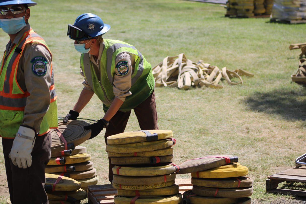 Fire personnel work to roll, stack, and store hose from the McKinney Fire at the Yreka base camp.