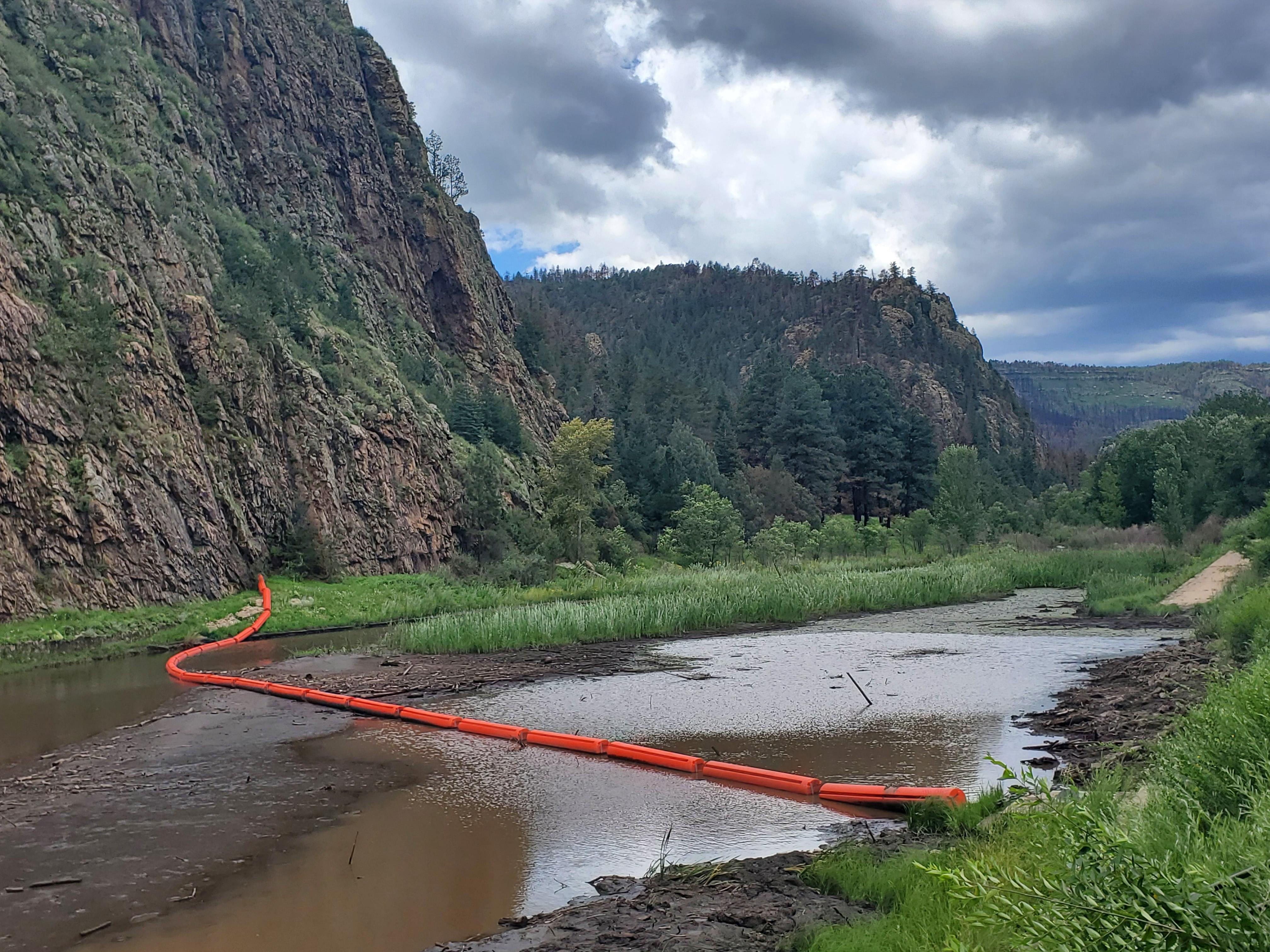 A foam barrier installed with a chain that spans a river. 