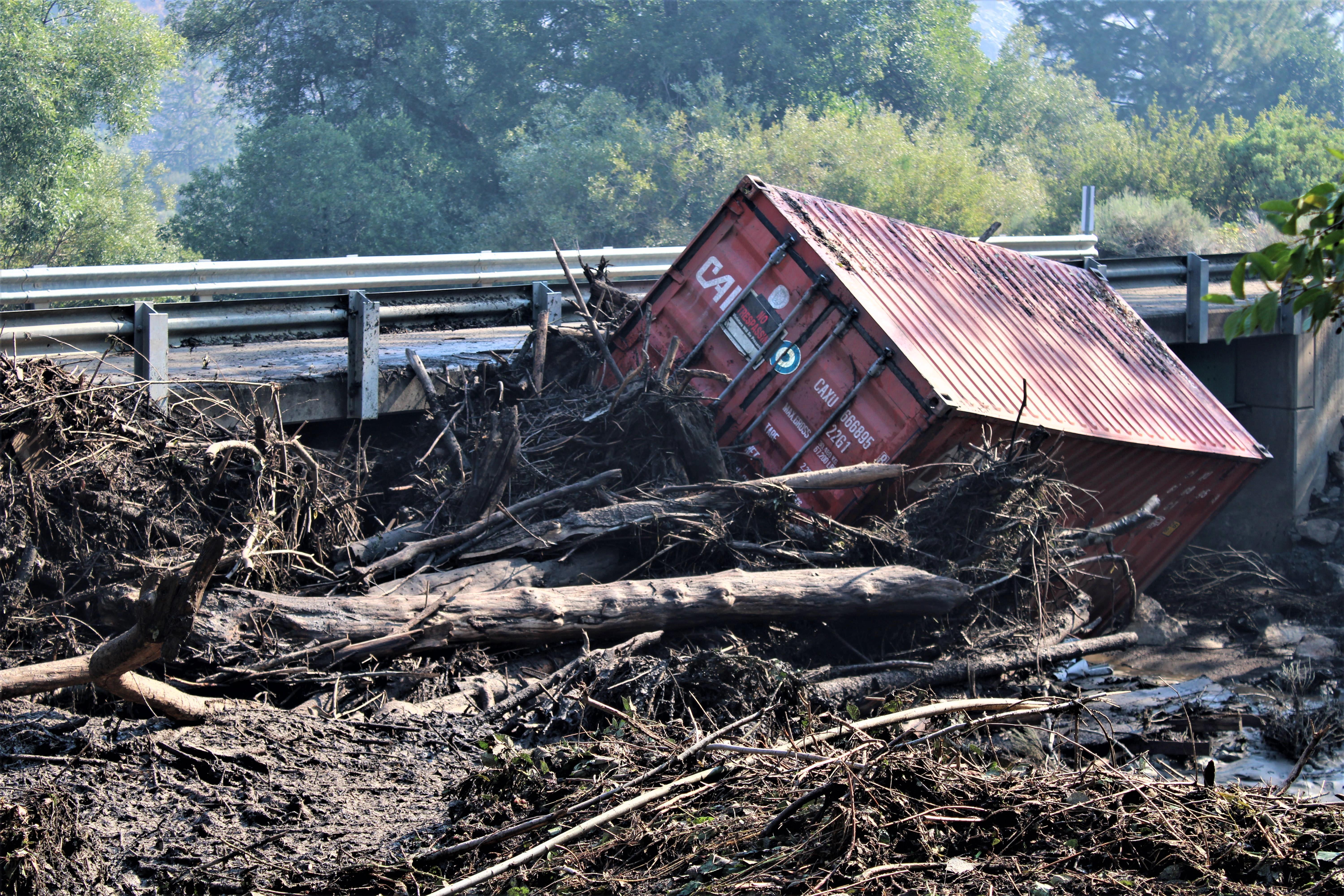 Image showing A steel storage container rests next to a bridge on Humbug Creek Road after 8-2-22 heavy rains that caused localized flooding and debris flows