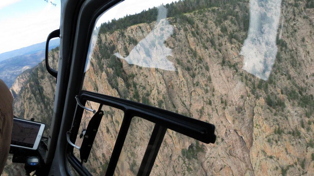 Helicopter flying over cliff face