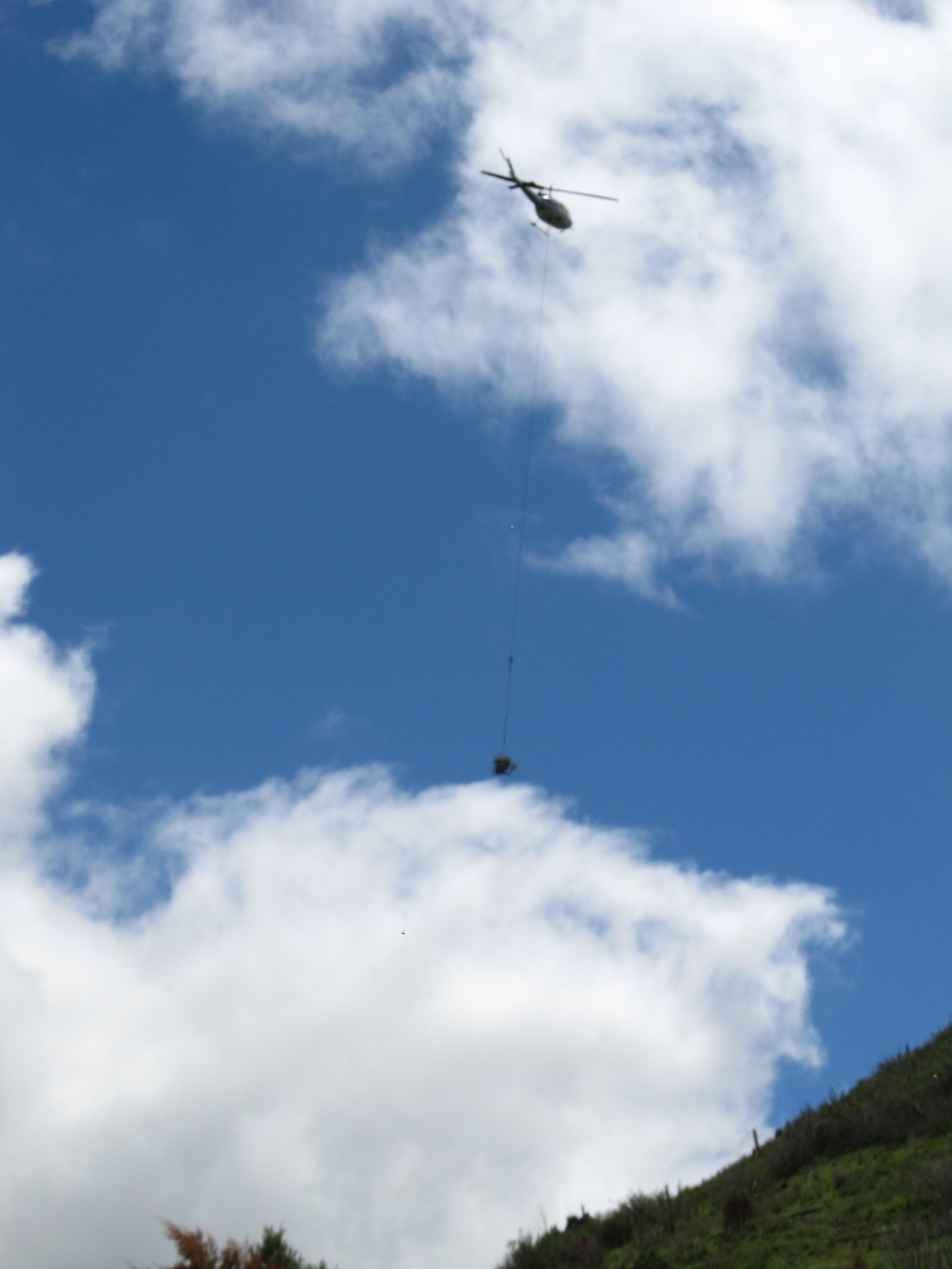 The seed hopper which is used to disperse the seeds, is suspended from the helicopter by a 100' long line
