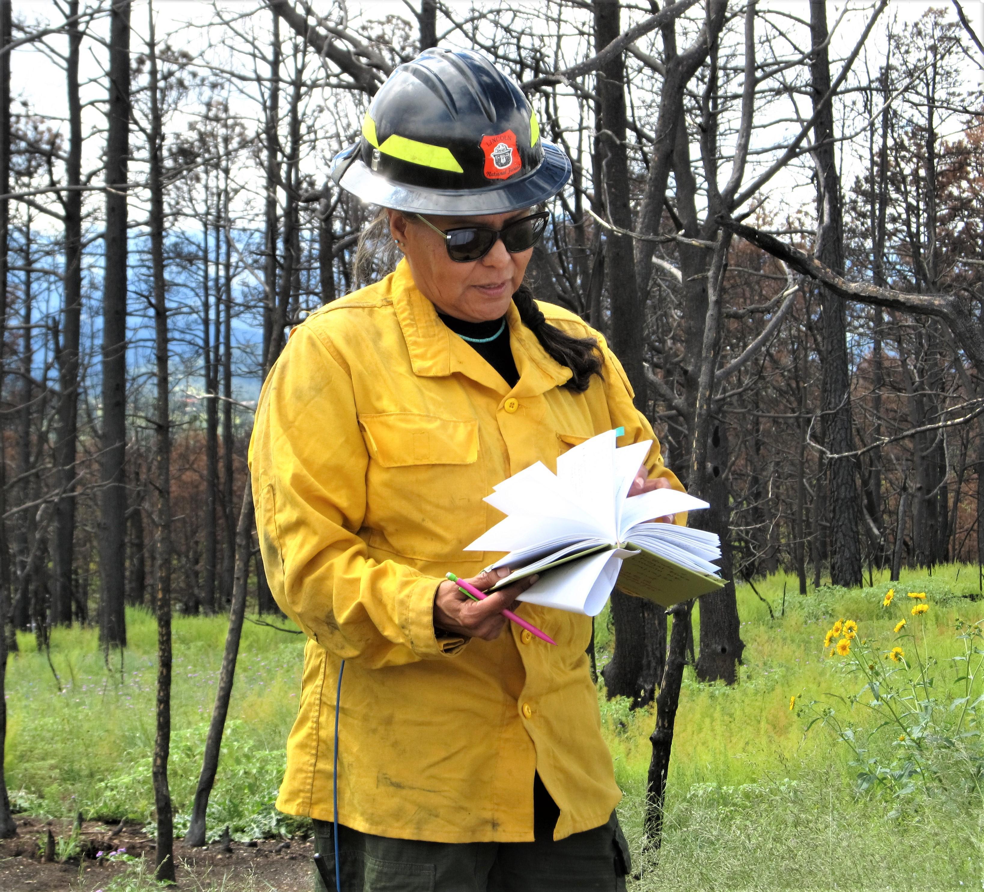 BAER Team Lead shown with notebook in hand ready to document site conditions during aerial seeding operations
