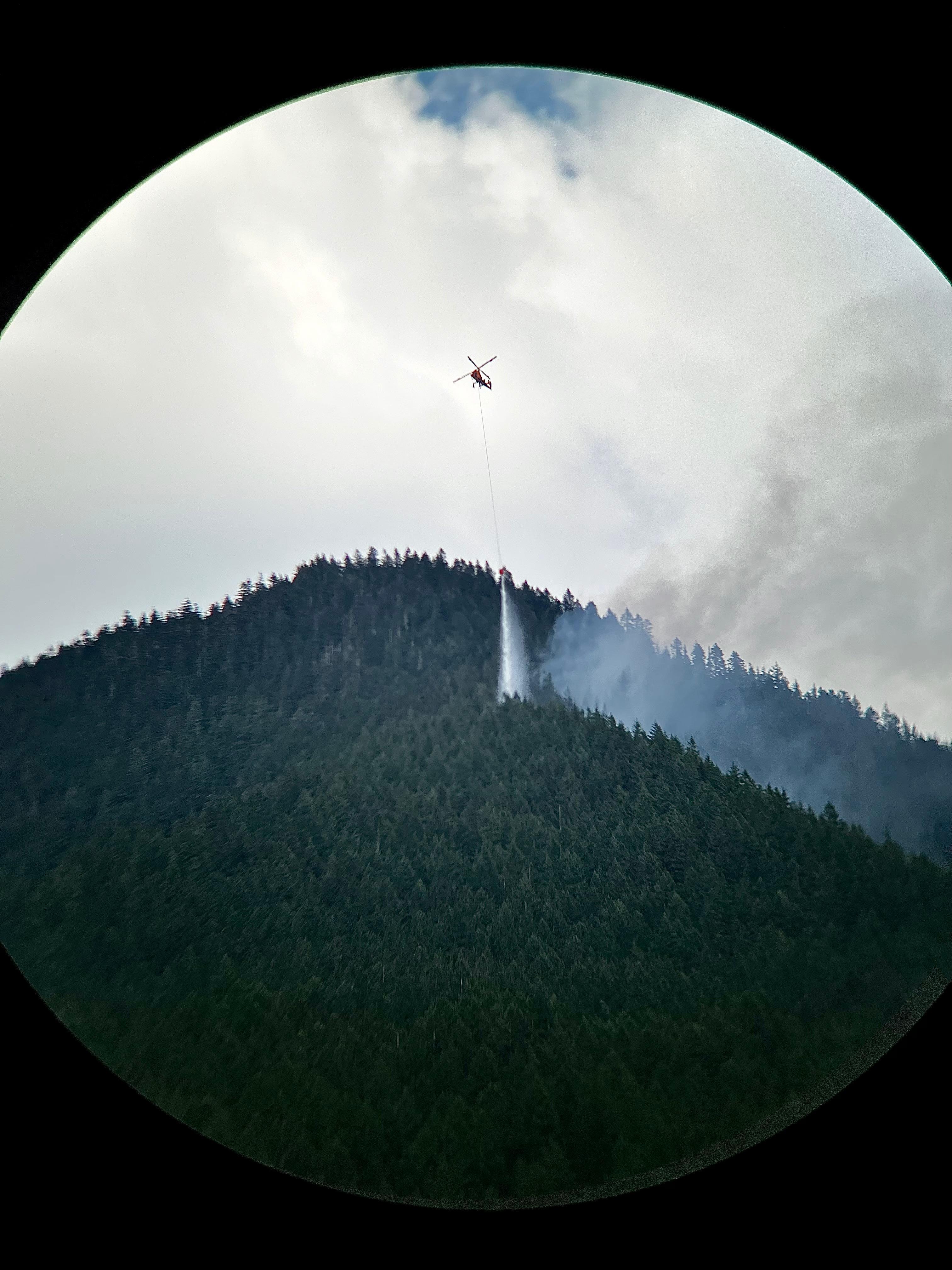 K MAX helicopter drops water on the Suiattle River Fire.