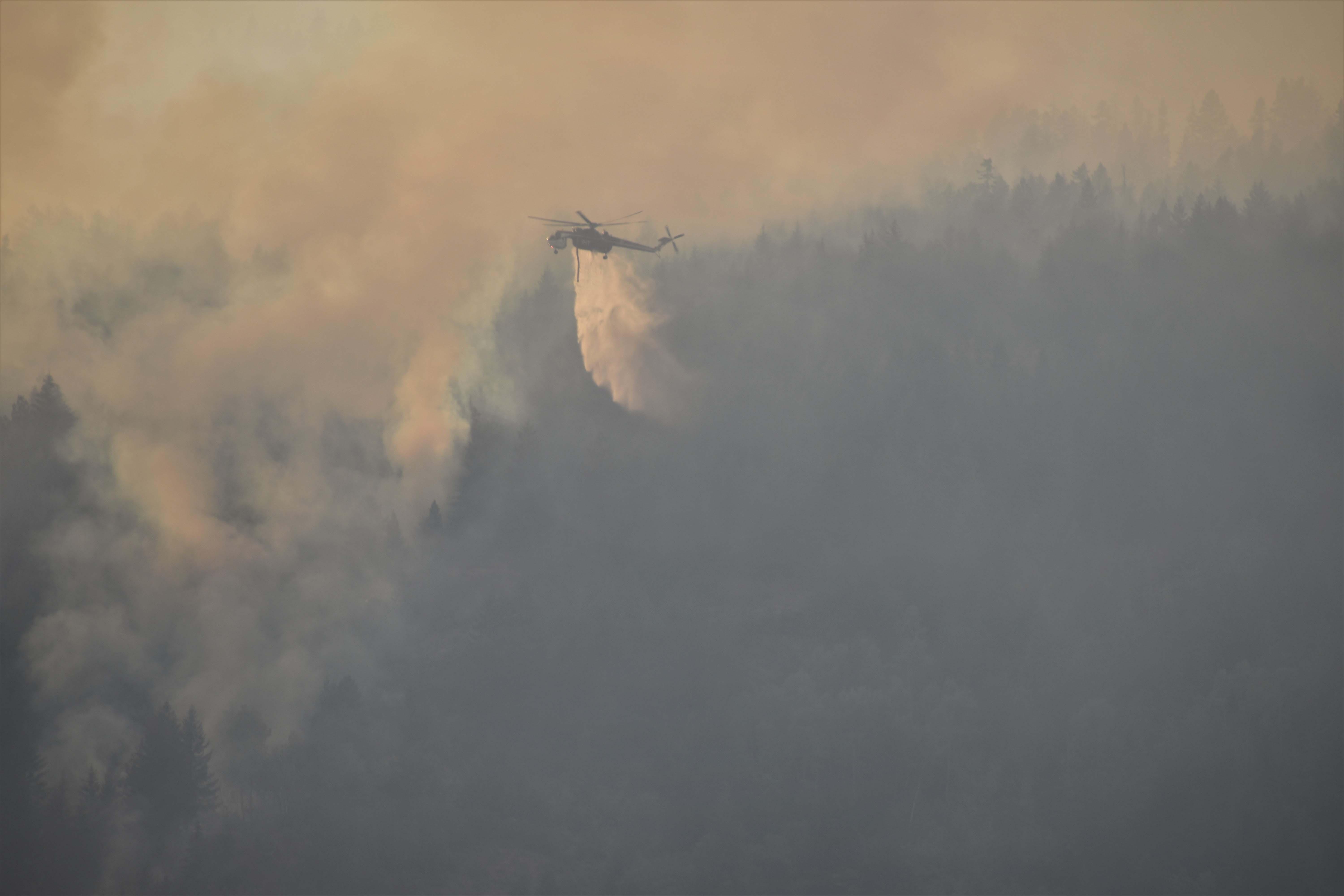 Type 1 Helicopter dropping water on the Kootenai River Complex fire in a smoky conditions.