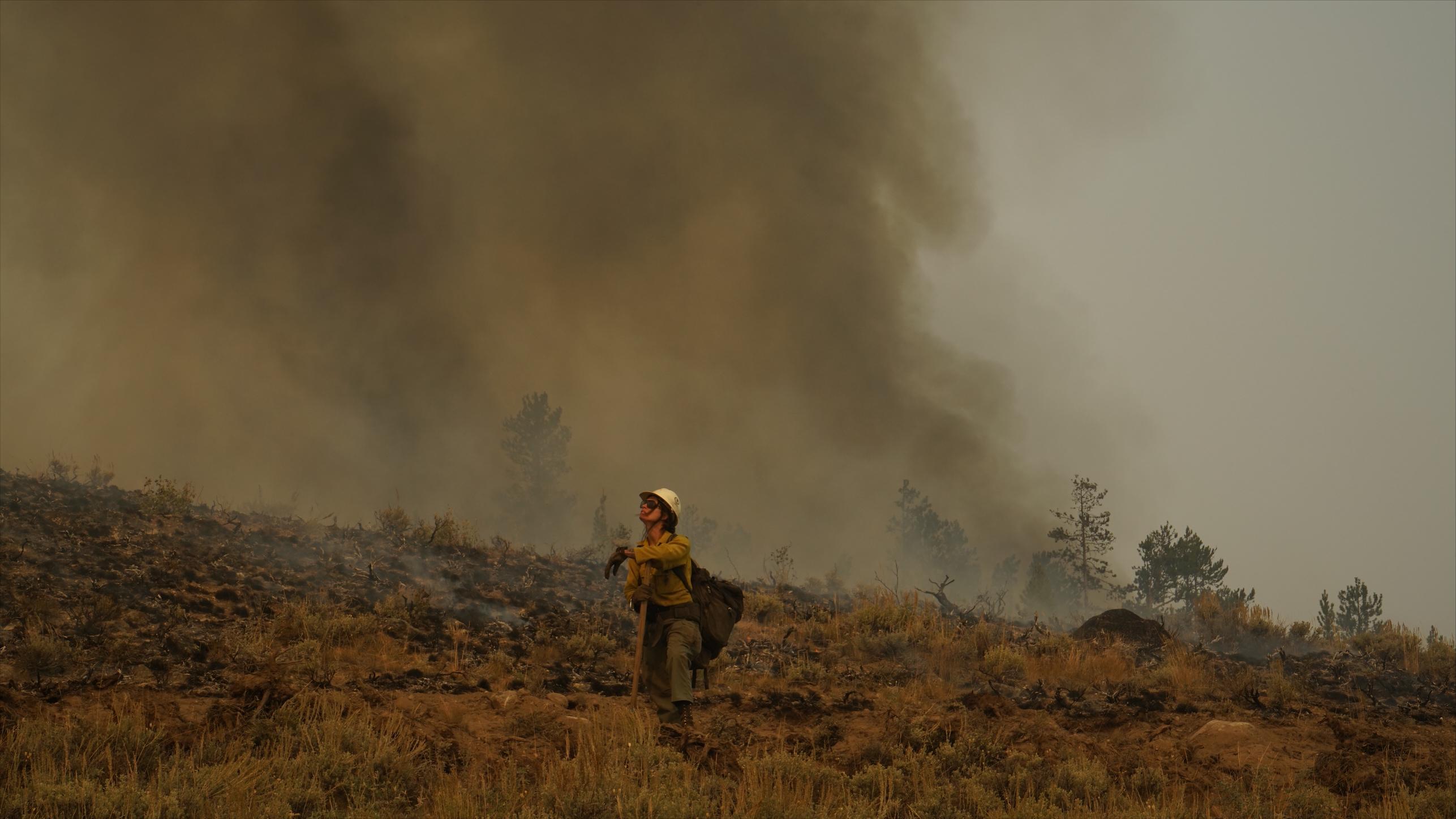 Firefighter watches for smoke direction changes during high winds