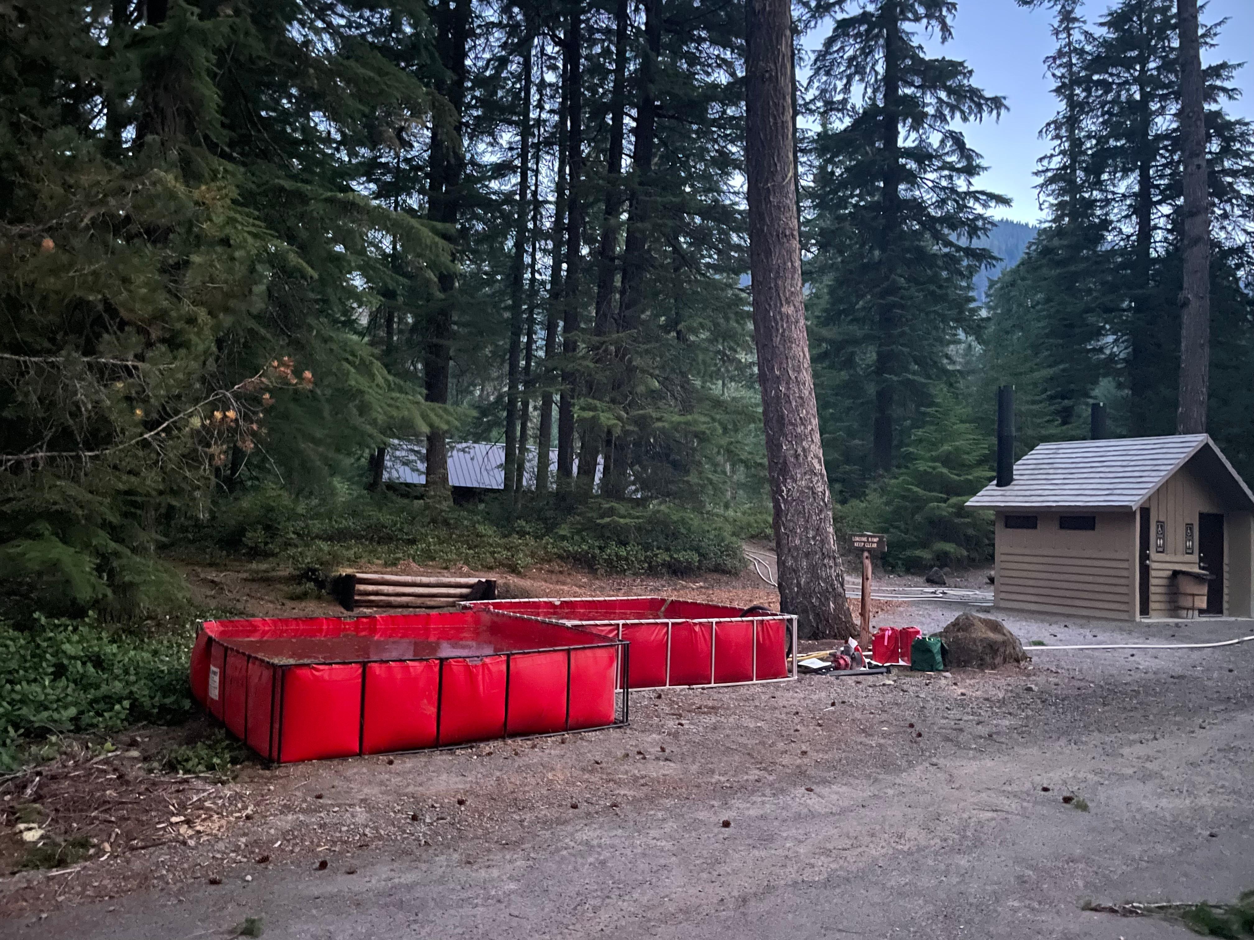 These red 3000 gallons tanks are ready for firefighters to pull water from to defend the structure at Kalama Horse Camp. The crew fills them up with tankers and leave in place until needed.