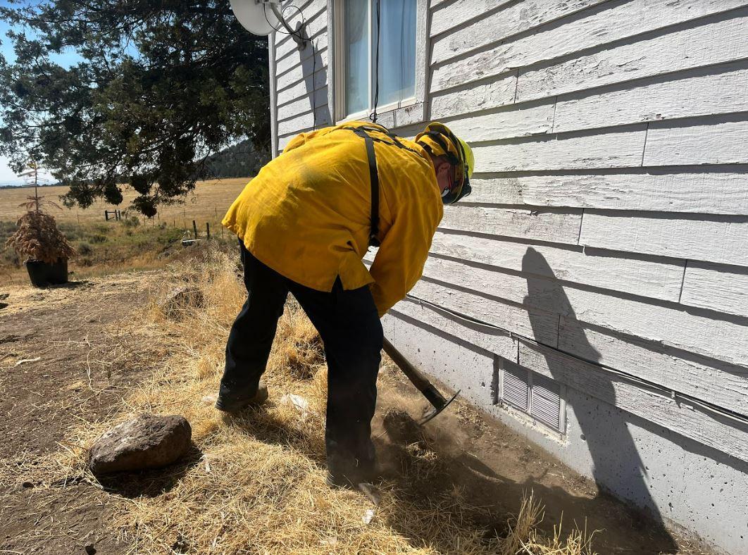 Firefighter creating defensible space around a strucutre