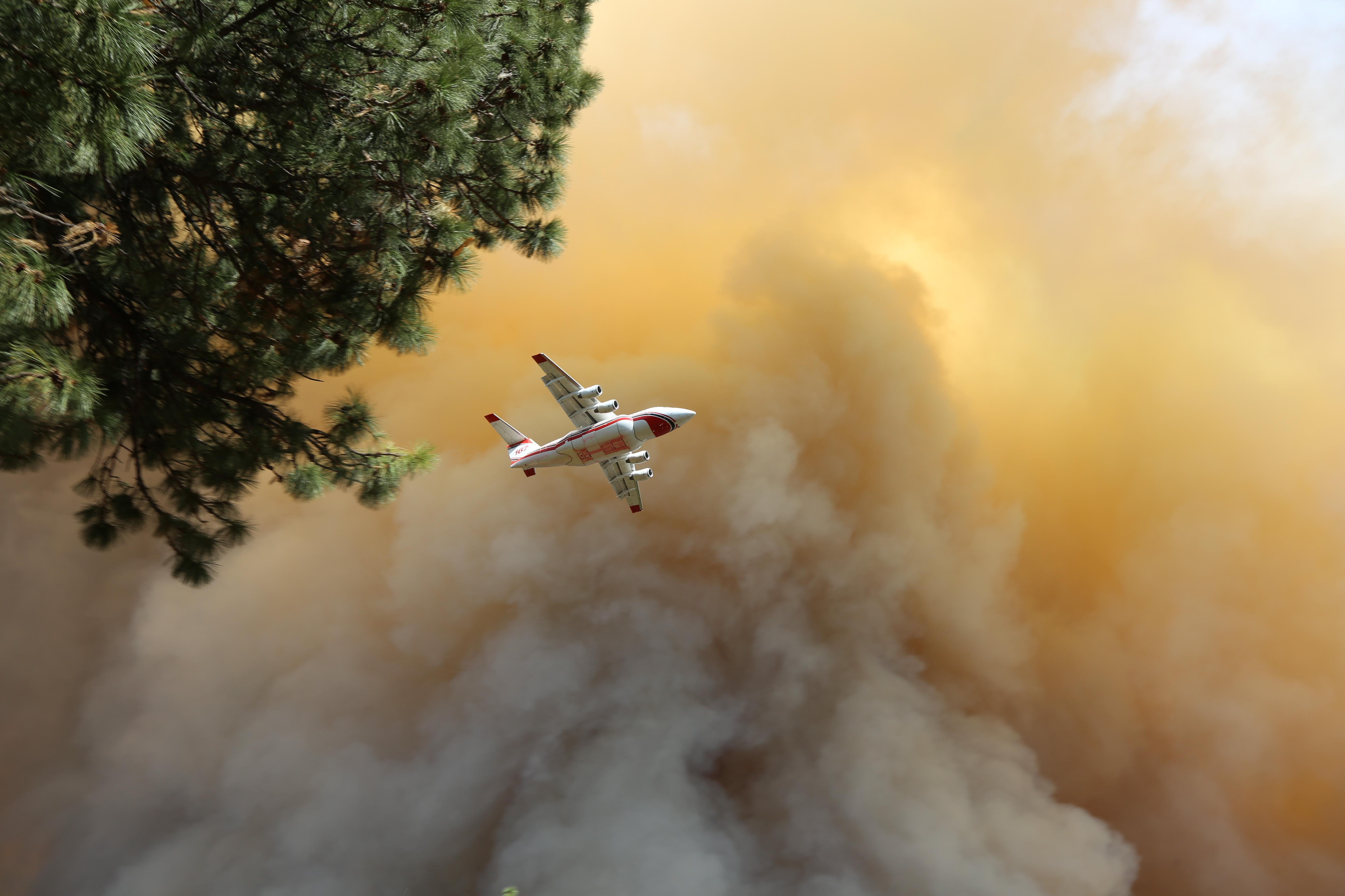 A retardant-dropping air tanker flying in thick smoke from the the spot fire that crossed American River Tuesday afternoon and grew quickly northward toward Foresthill, California.