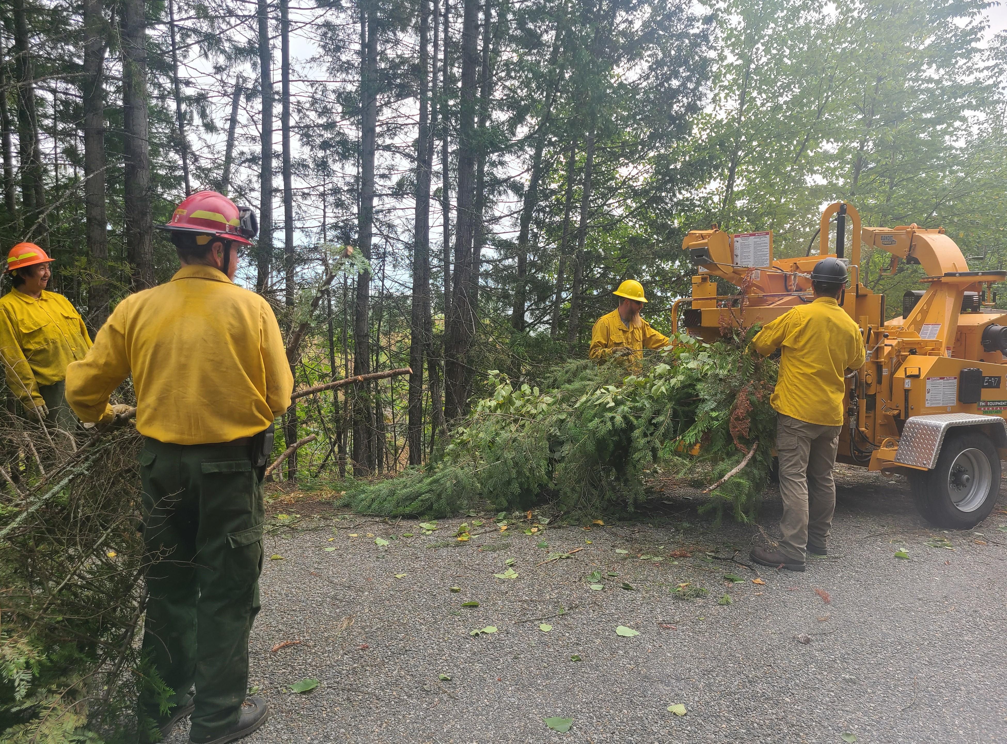 Crews chipping vegetation on the West Side Road