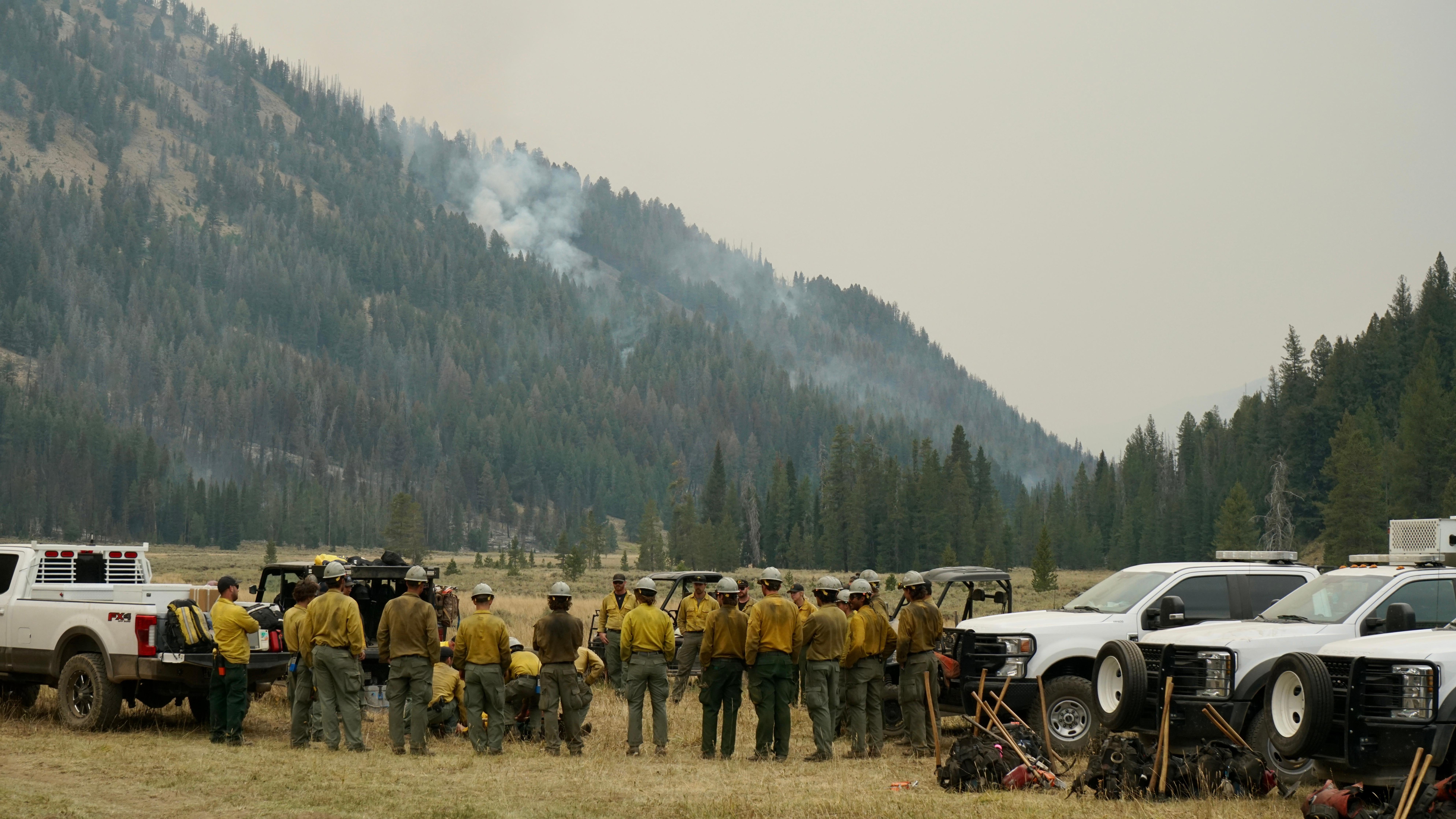 firefighters gather to hear instructions for the day at a scenic spot