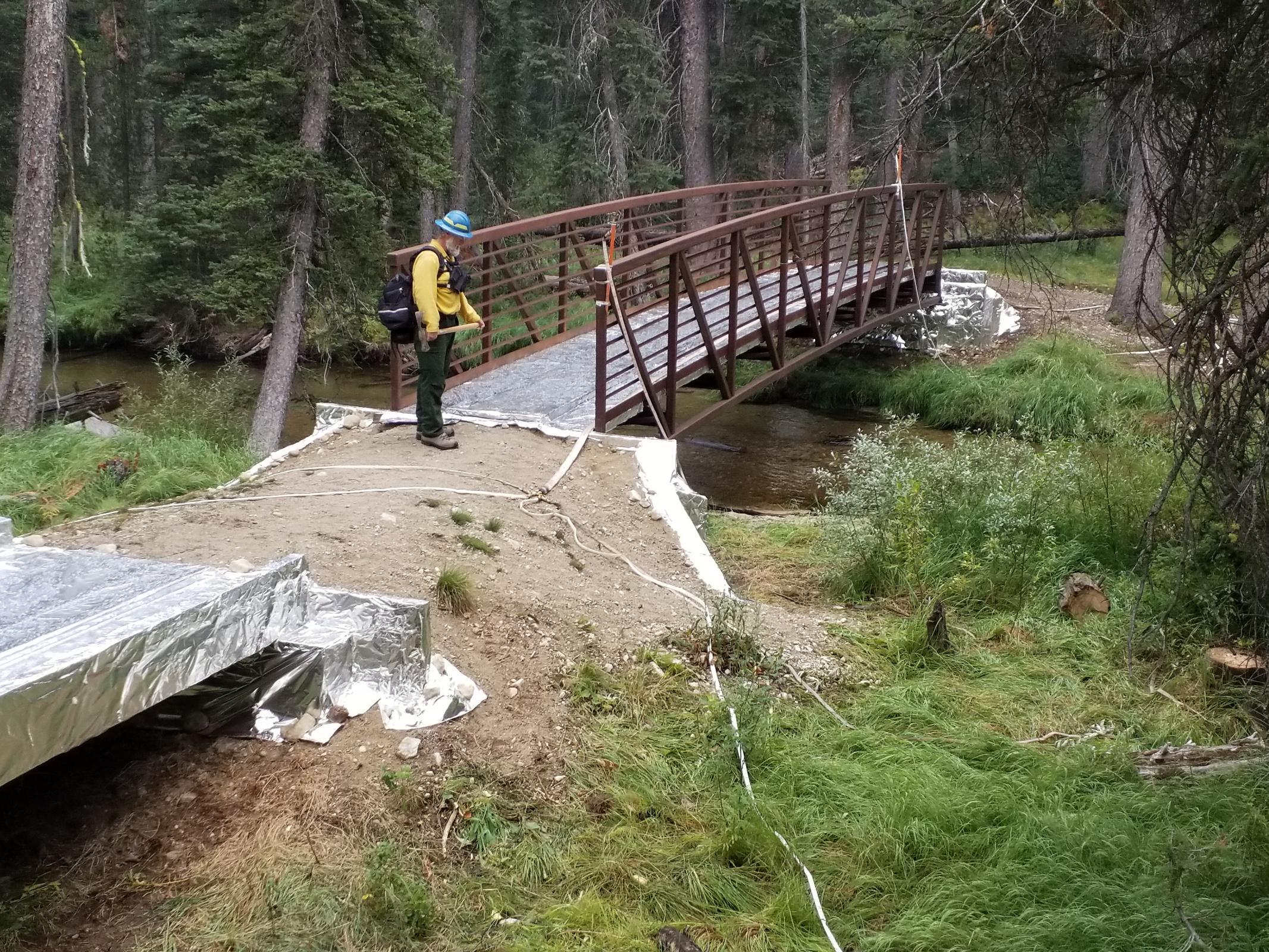 Forest Engineer inspects protection measures on a bridge at  Alpine Creek, located on the trail network above the Alturas lake trailhead.