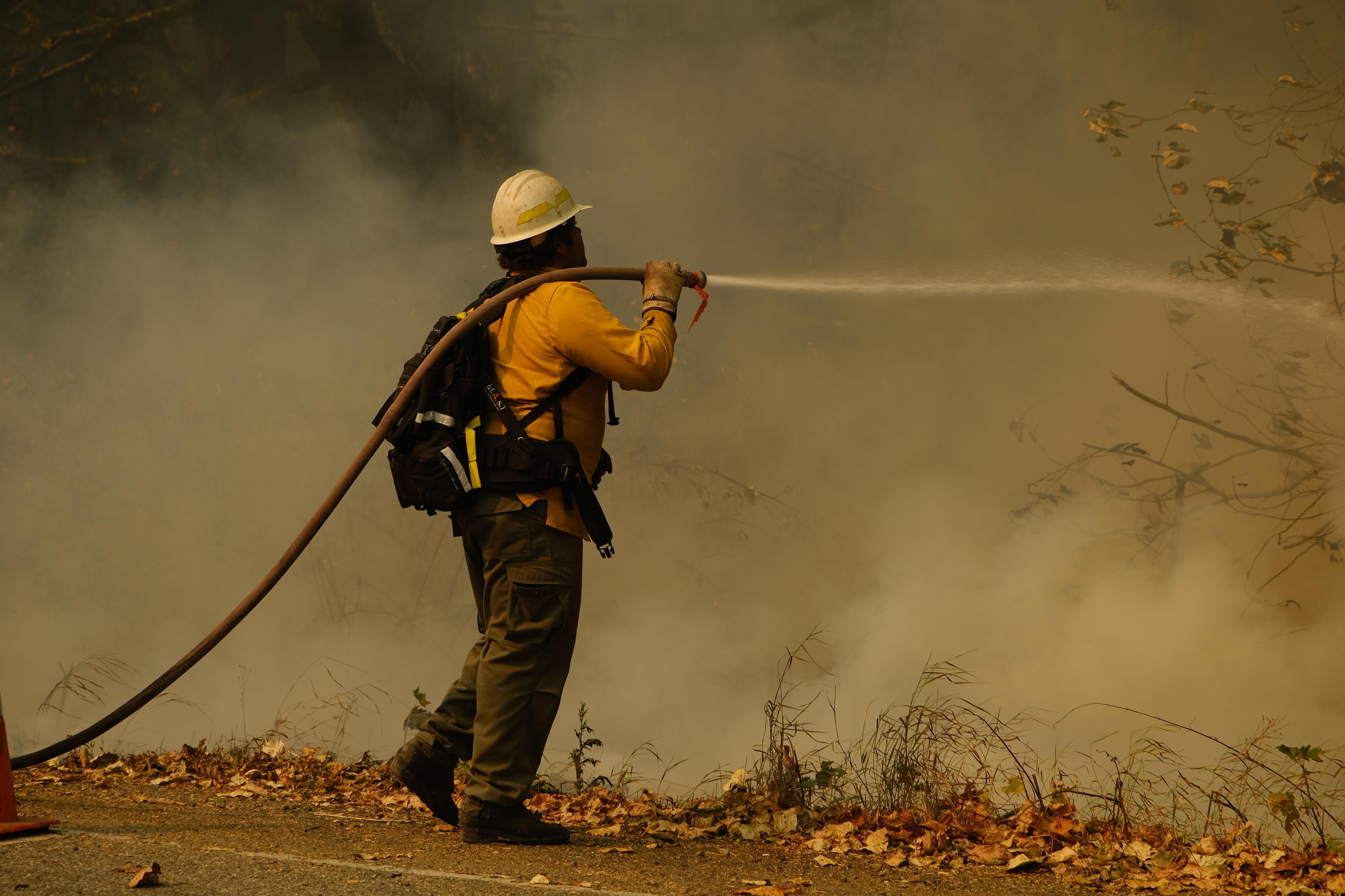 A firefighter works a flare up near Beckler Road and US 2.