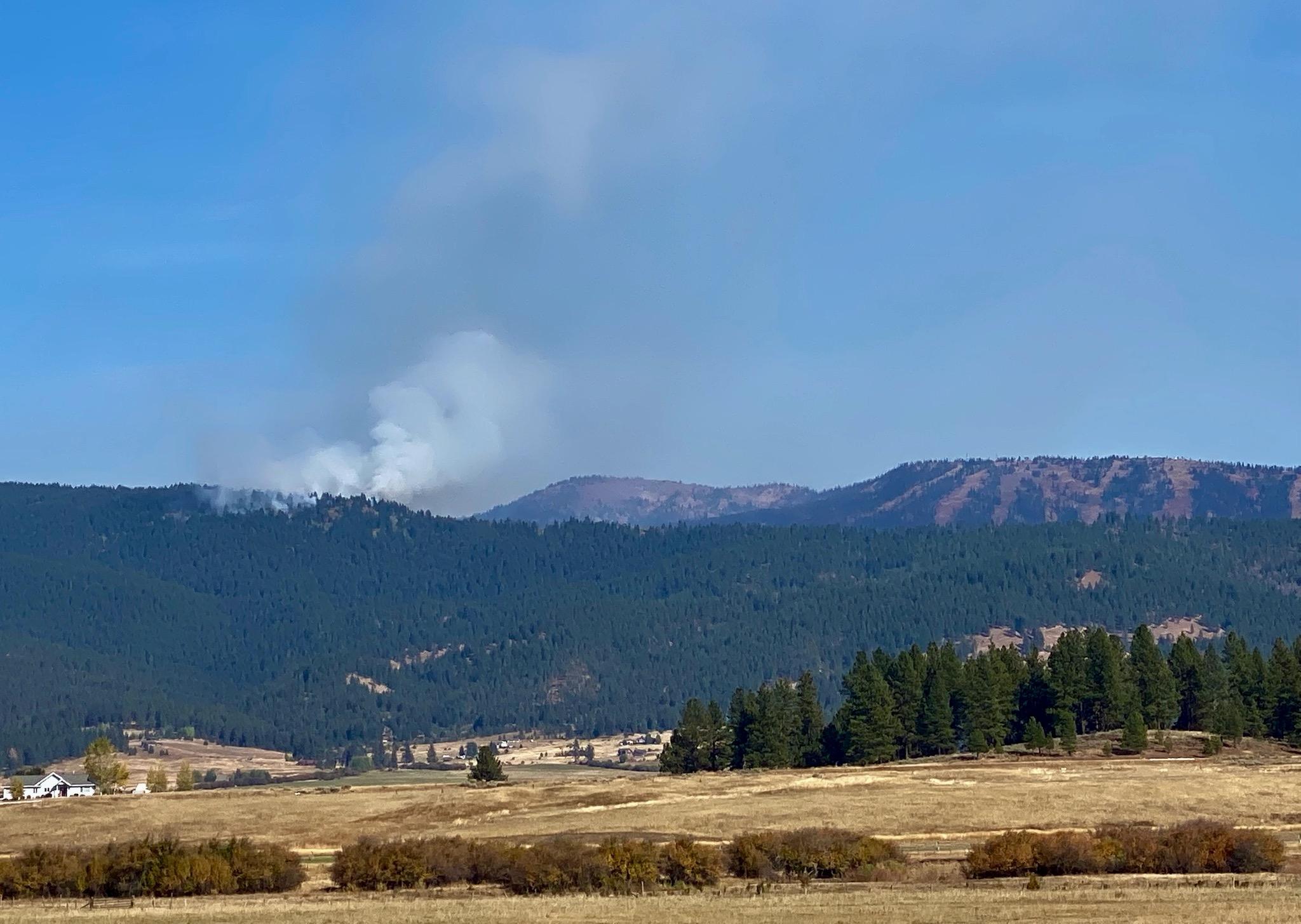 Smoke rises from a tree-covered ridge in the Payette National Forest on the first day of a prescribed burn Oct. 5, 2022.
