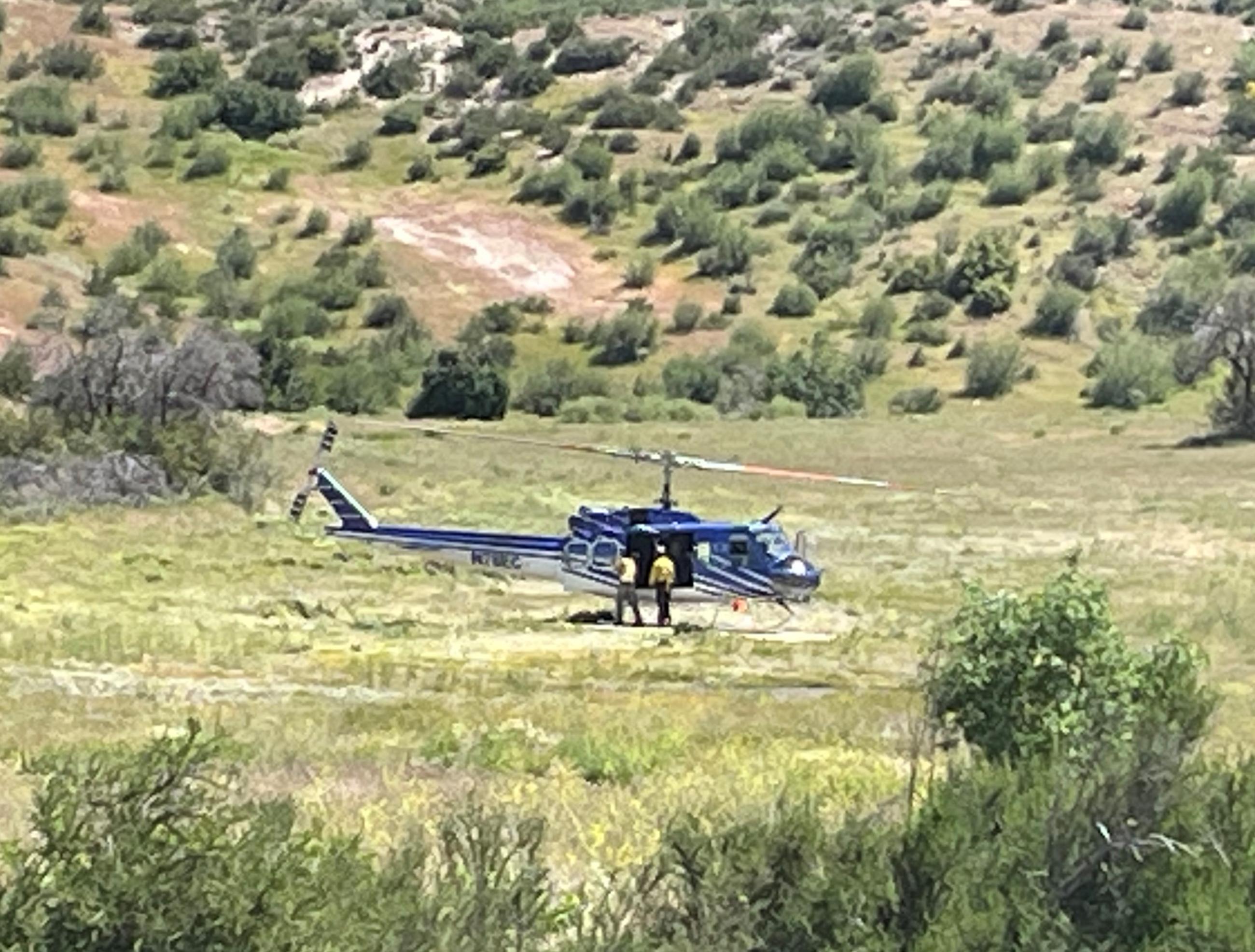 Helicopter in field being readied for flight.