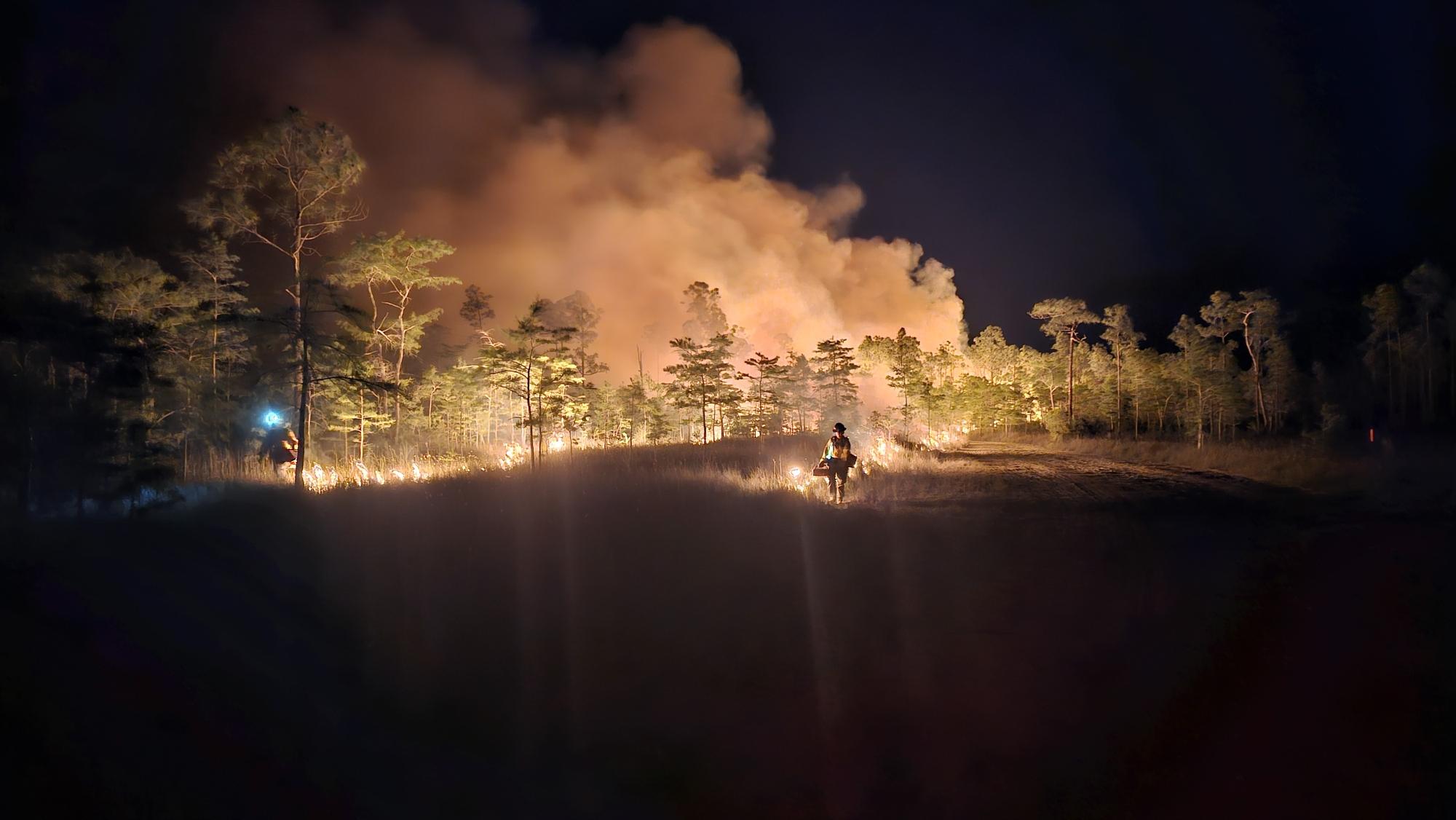 Firefighter conducts burnout operation during night operations