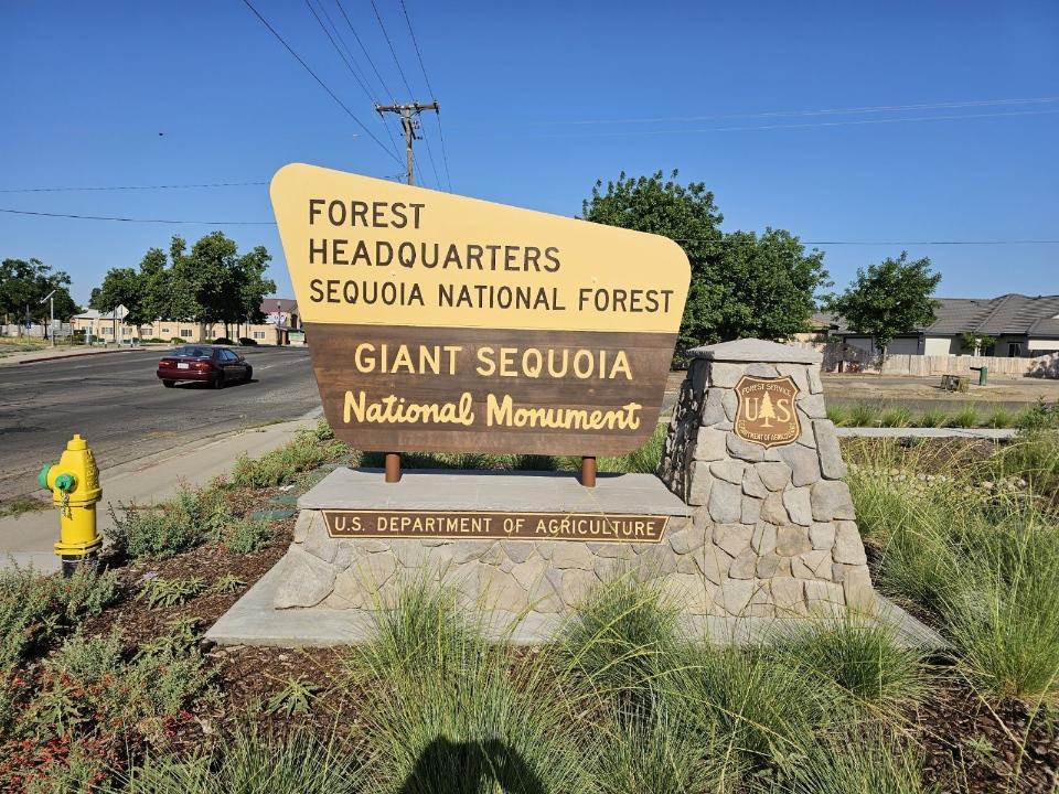 Photo shows a Yellow and Brown Forest Sign reading "Forest Headquarters - Sequoia National Forest