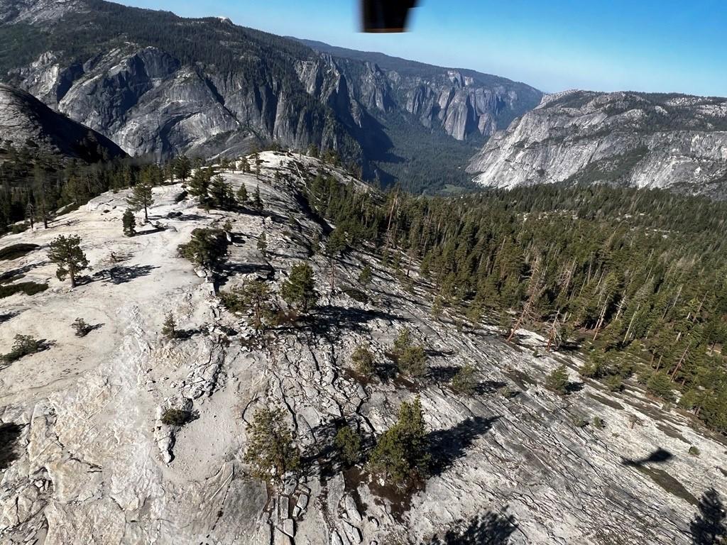 Aerial photo of Yosemite's North Dome - a granite outcropping surrounded by forest