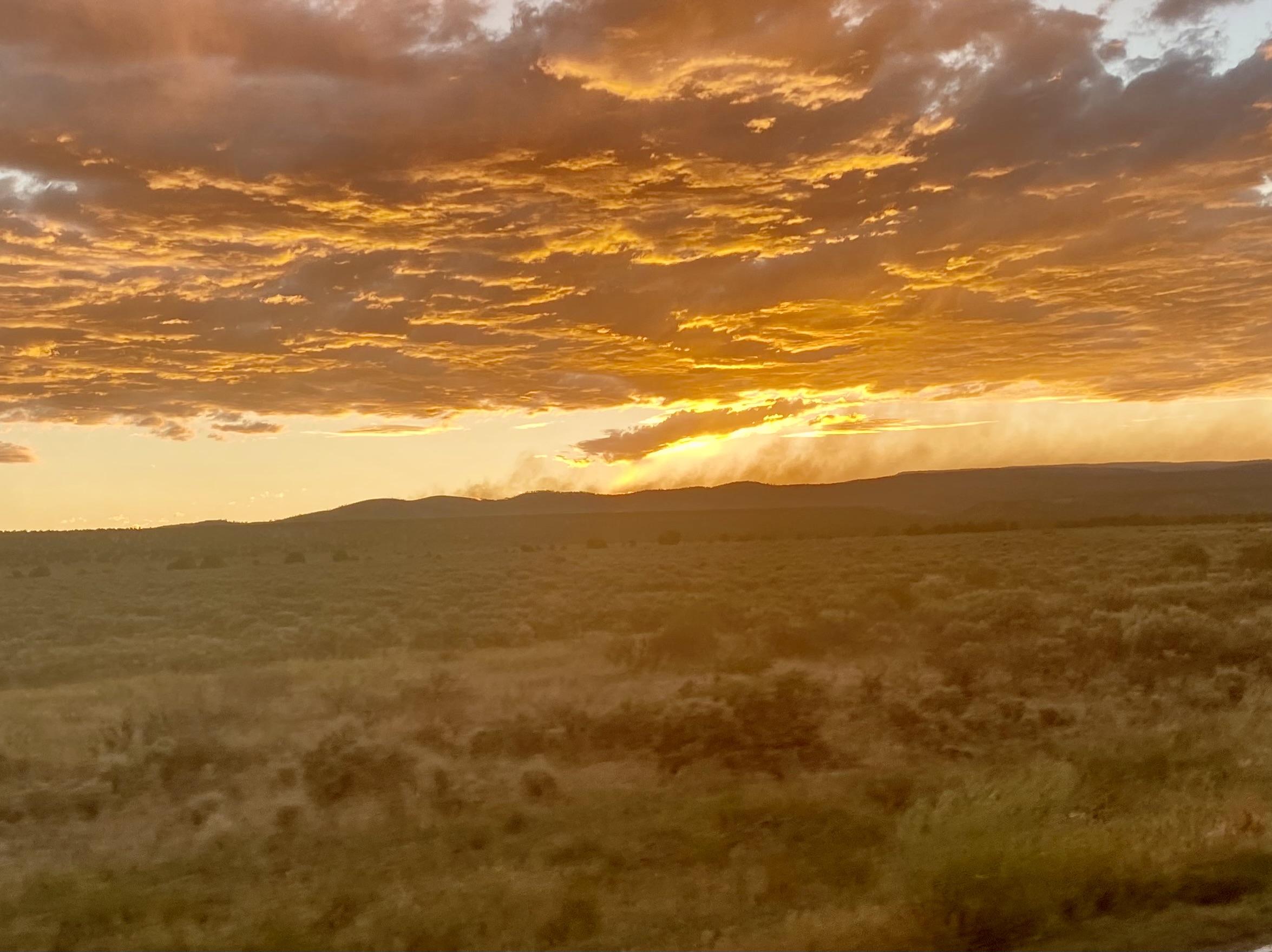 Smoke rising from the ridgeline through the sunset.