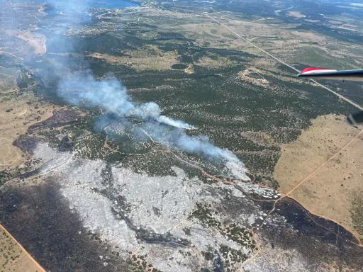 A photo of the entire black and smoking scar taken looking down from a plane.